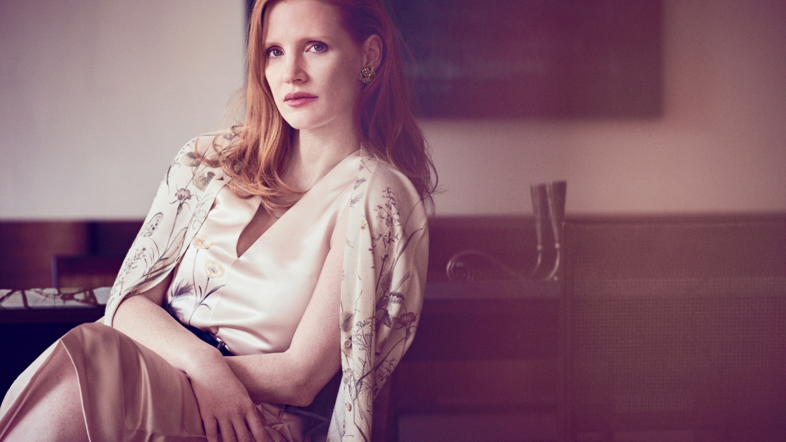 Молодая рыжеволосая актриса Джессика Честейн сидит на стуле