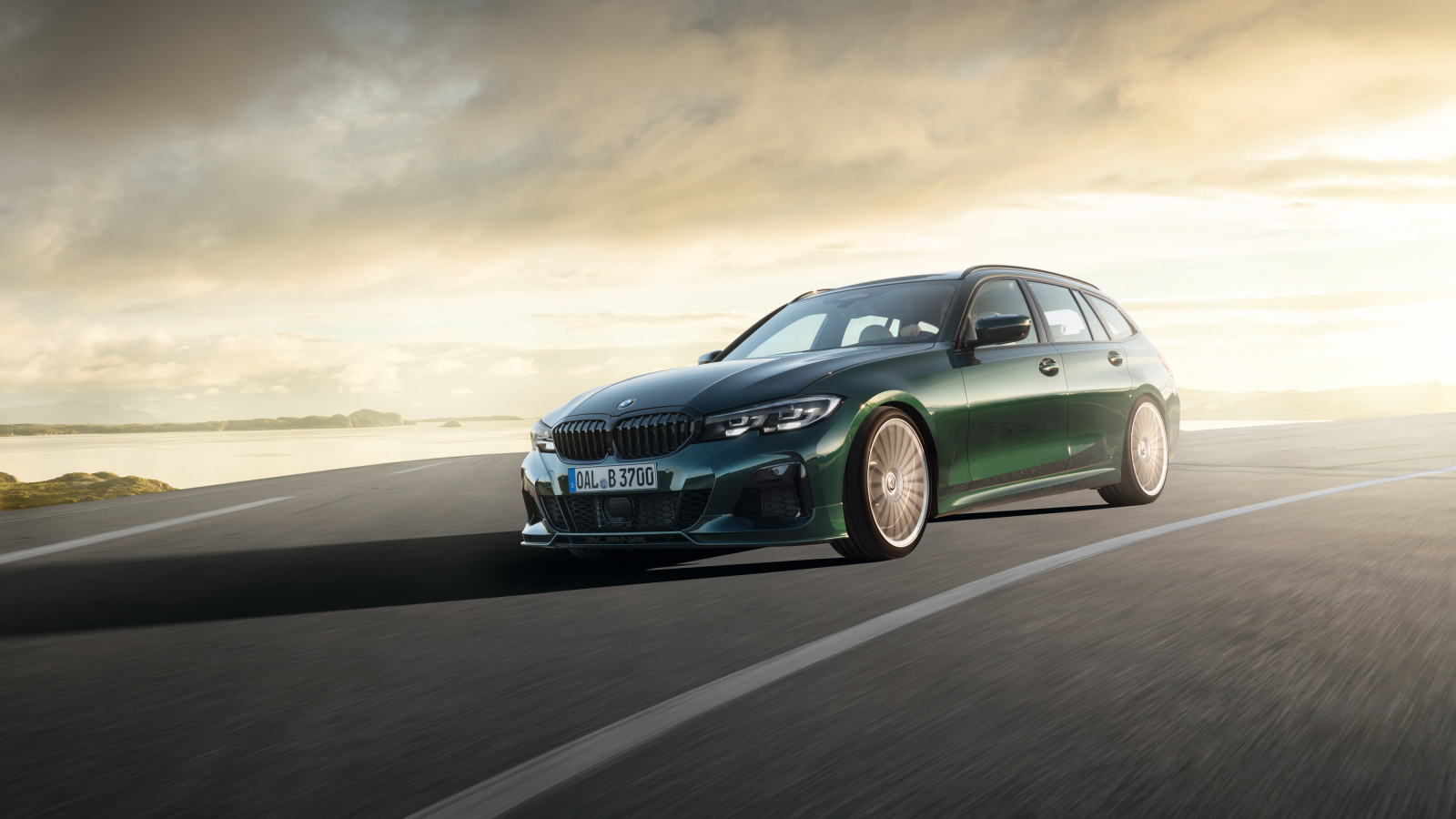 Зеленый автомобиль Alpina B3 Touring 2019 года на дороге