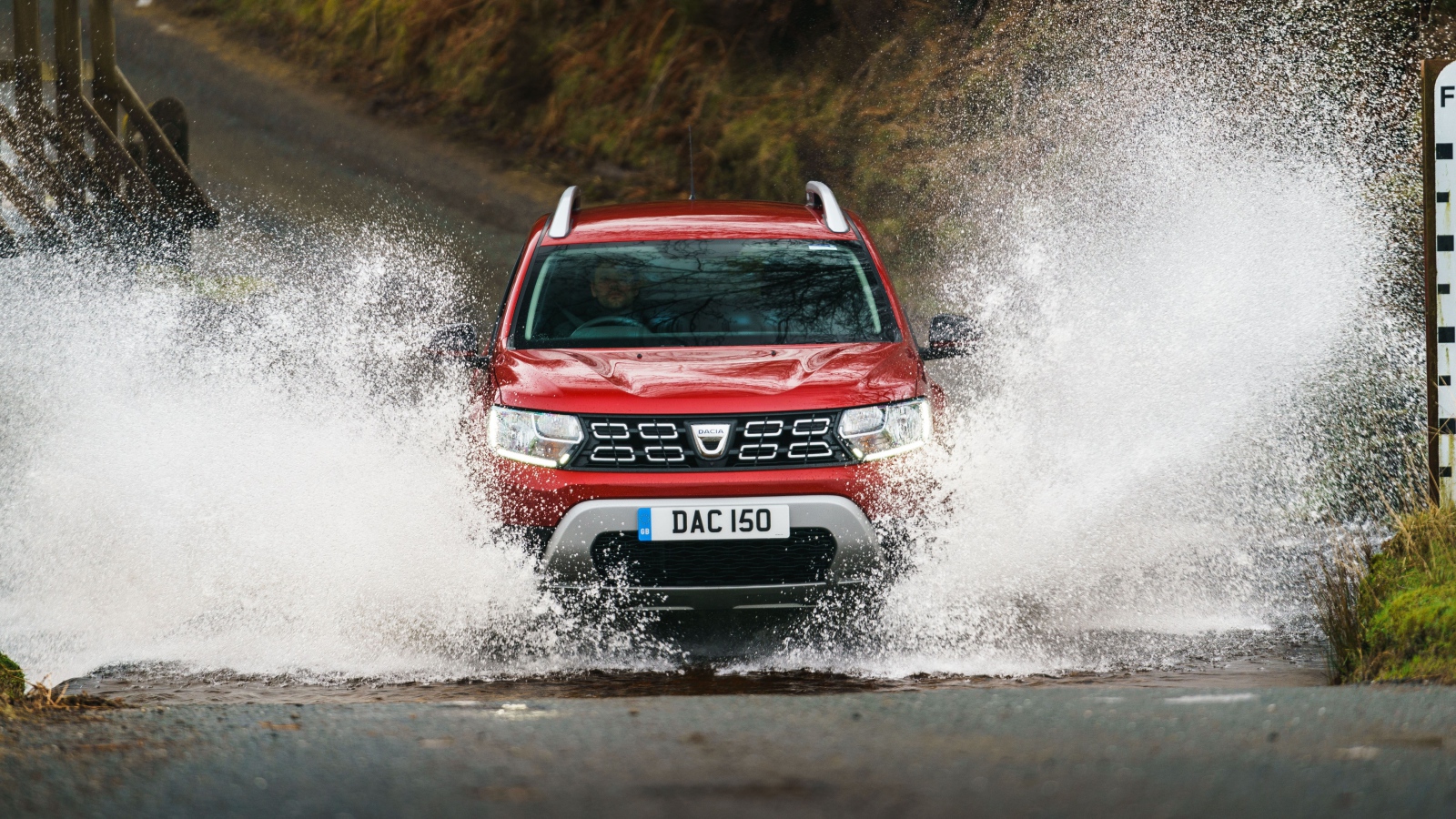 Красный внедорожник Dacia Duster Techroad 2019 года едет по воде