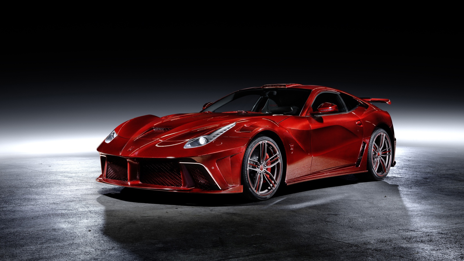 Красный автомобиль Mansory La Revoluzione на сером фоне