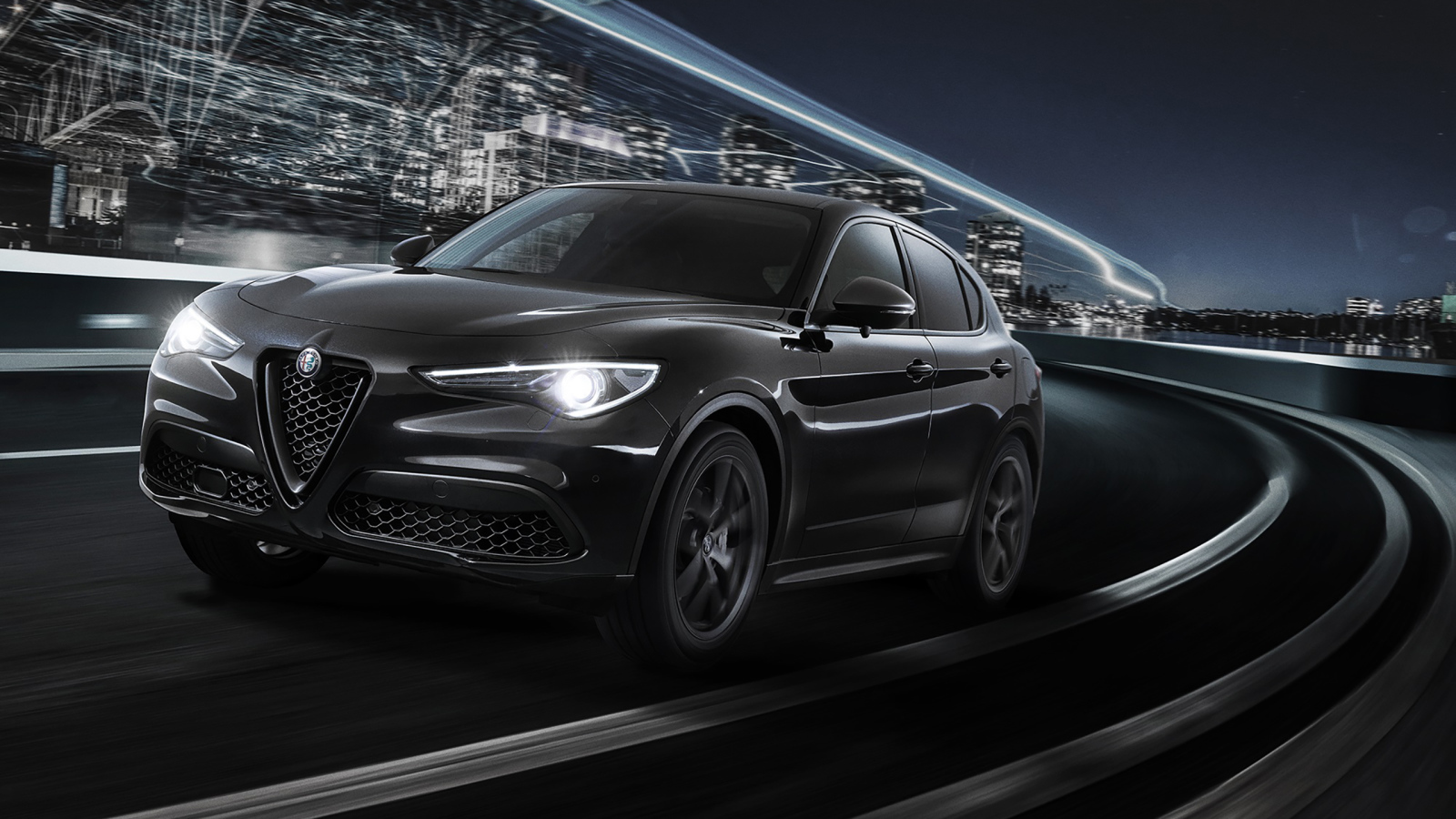 Черный автомобиль Alfa Romeo Stelvio, 2019 года на трассе