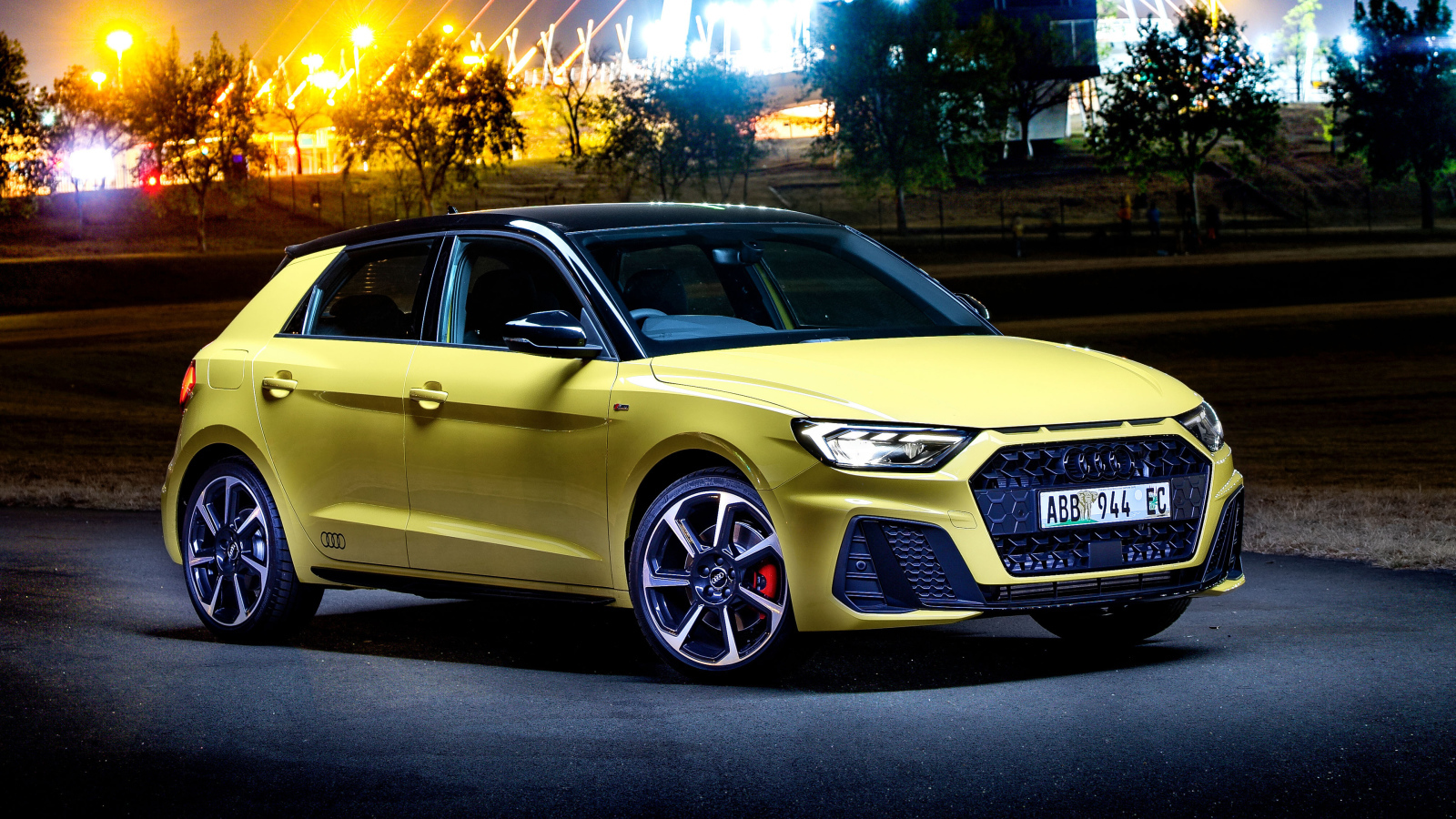 Желтый автомобиль Audi A1 Sportback 40 TFSI S Line Edition One 2019 года на фоне ночного города
