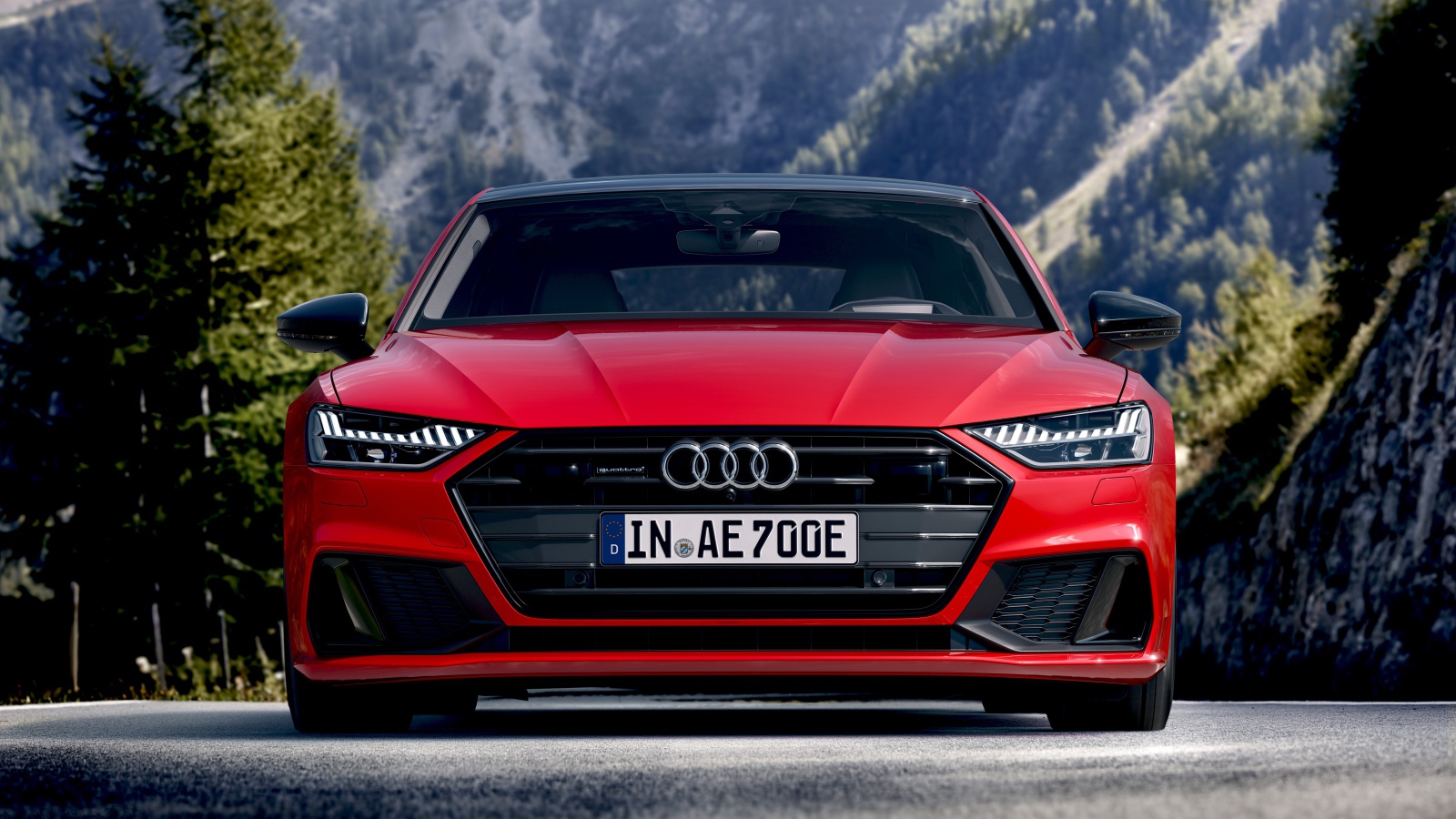 Красный автомобиль Audi A7 Sportback 55 TFSI E Quattro S Line 2019 года на трассе 