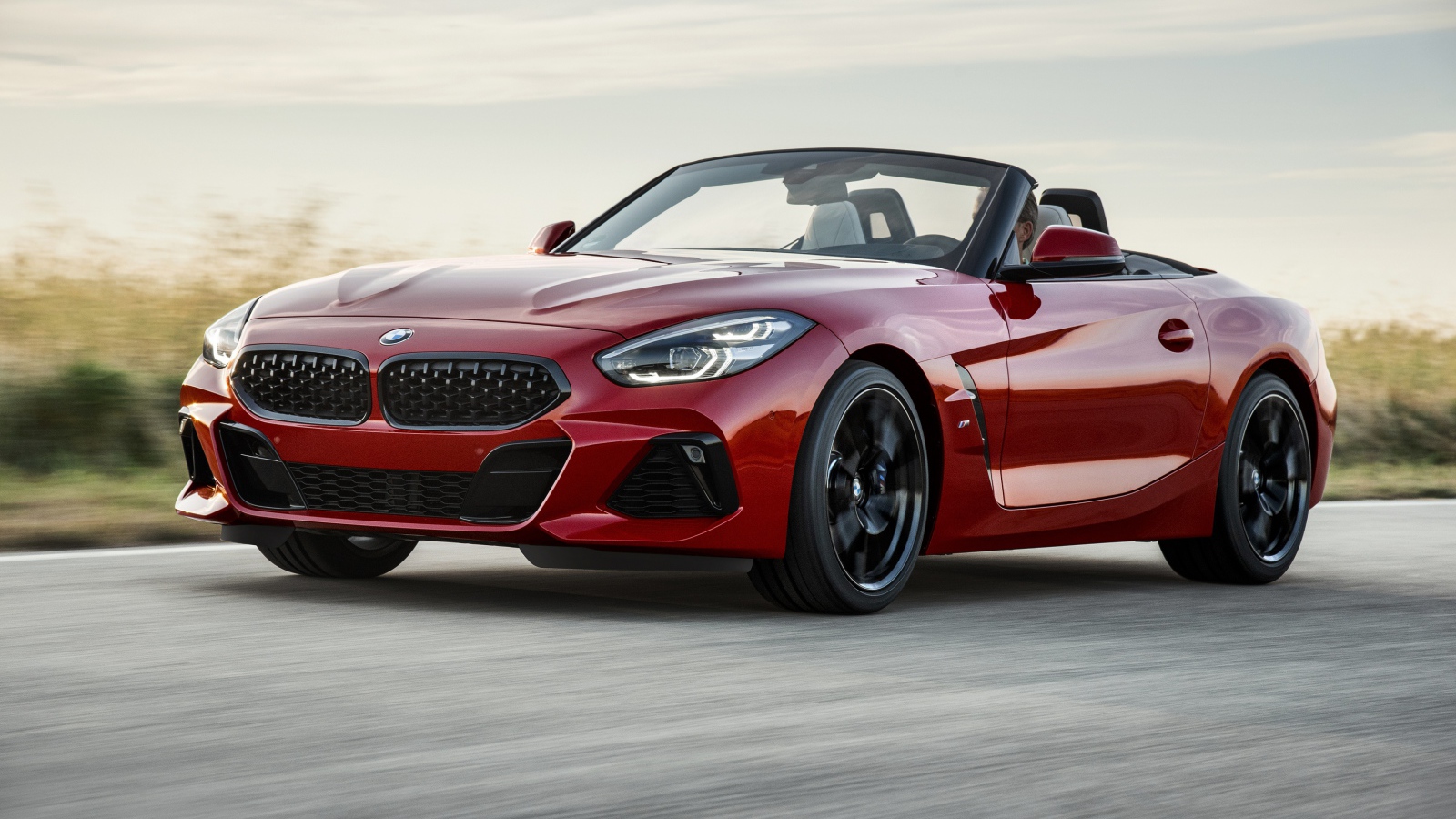 Красный автомобиль кабриолет BMW Z4 на дороге