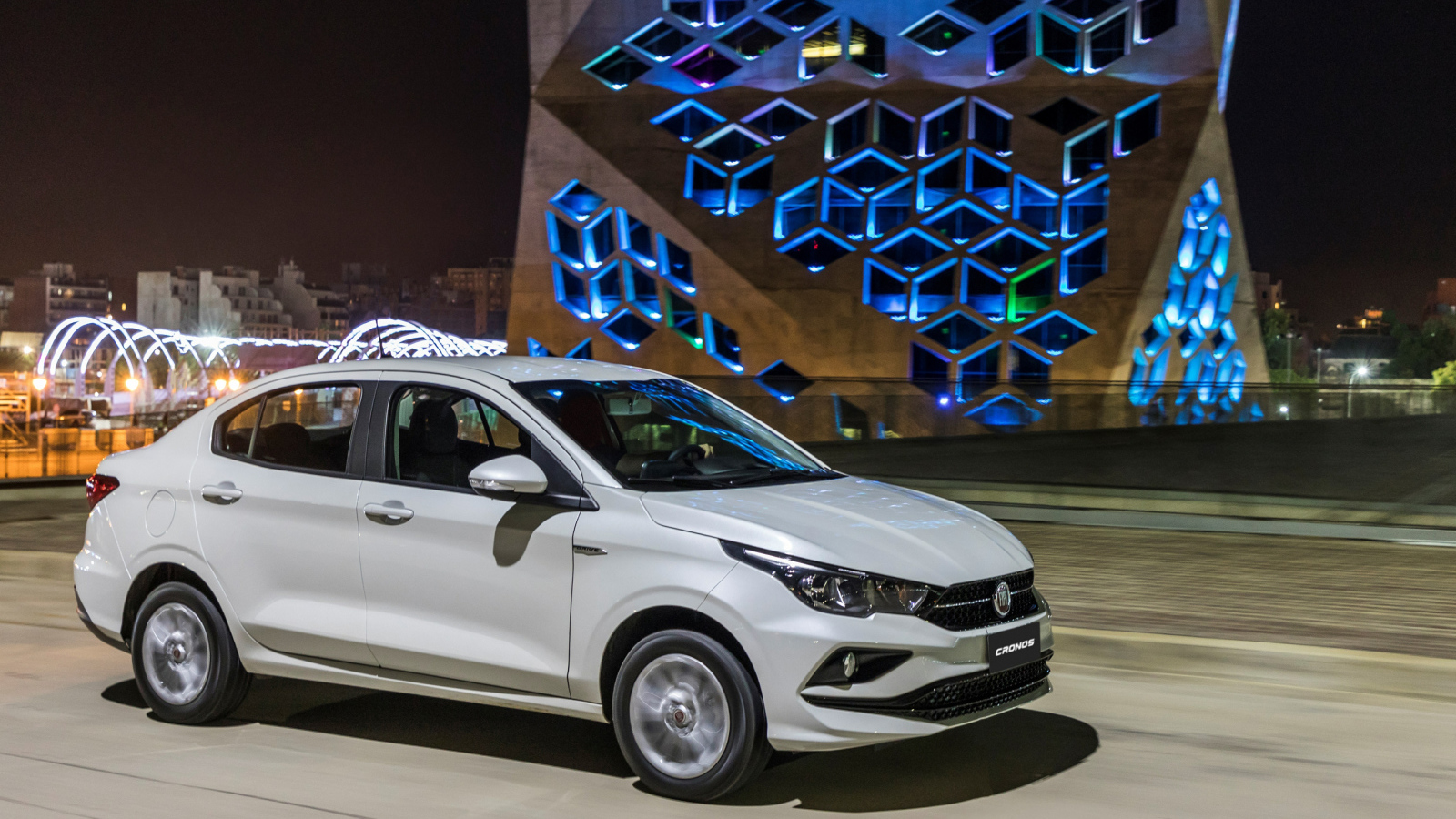 Белый автомобиль Fiat  Cronos, 2018 года на фоне здания