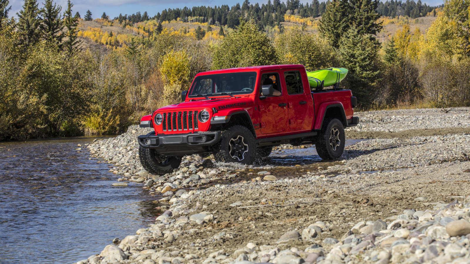 Красный пикап Jeep Gladiator Rubicon, 2020 года у реки