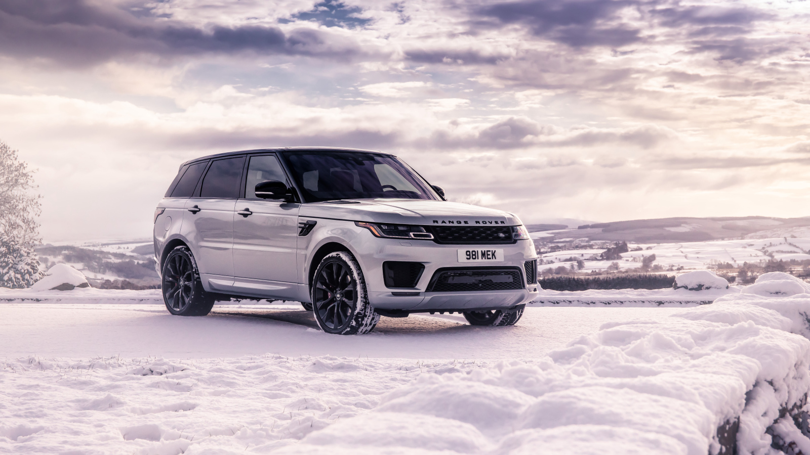 Серебристый внедорожник Range Rover Sport стоит на снегу