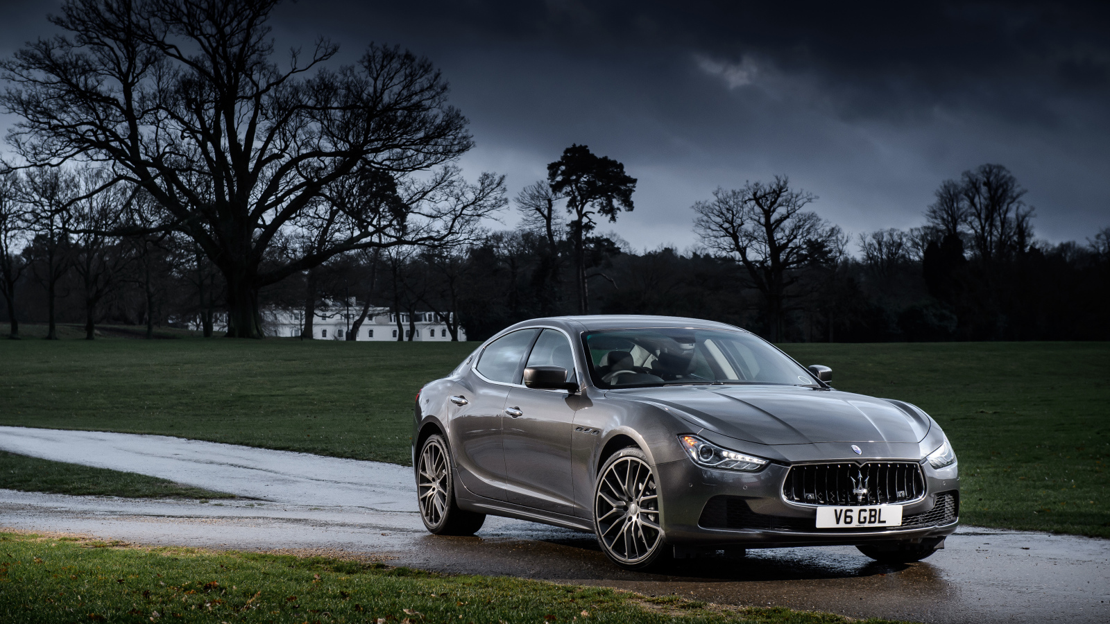 Серебристый автомобиль Maserati Ghibli на фоне грозового неба