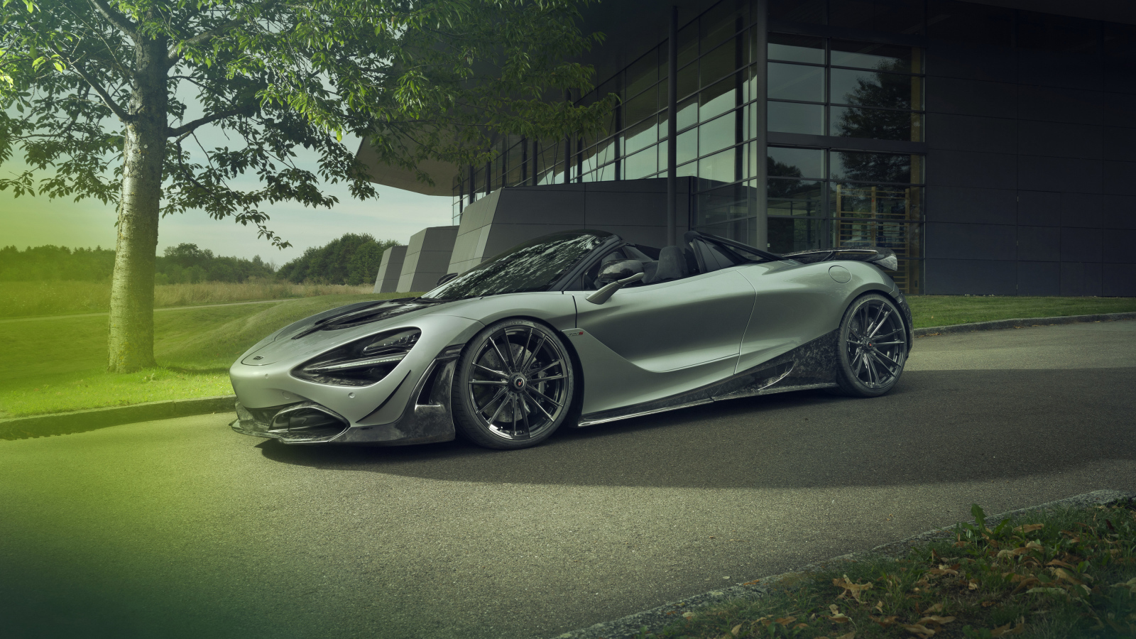 Серебристый автомобиль McLaren 720S Spider 2019 года у дома