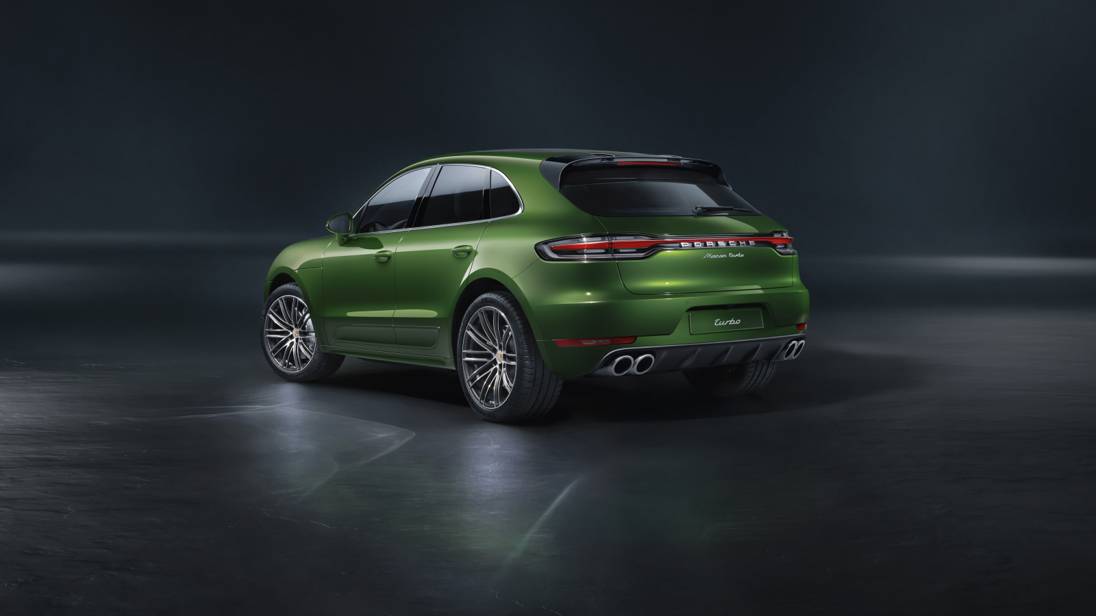 Зеленый автомобиль Porsche Macan Turbo 2019 года вид сзади