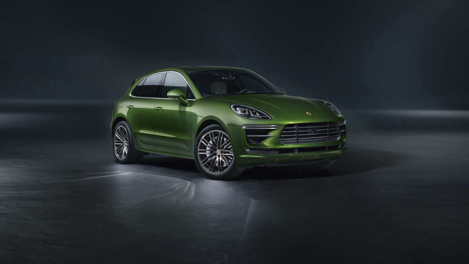 Зеленый автомобиль Porsche Macan Turbo 2019 года на сером фоне