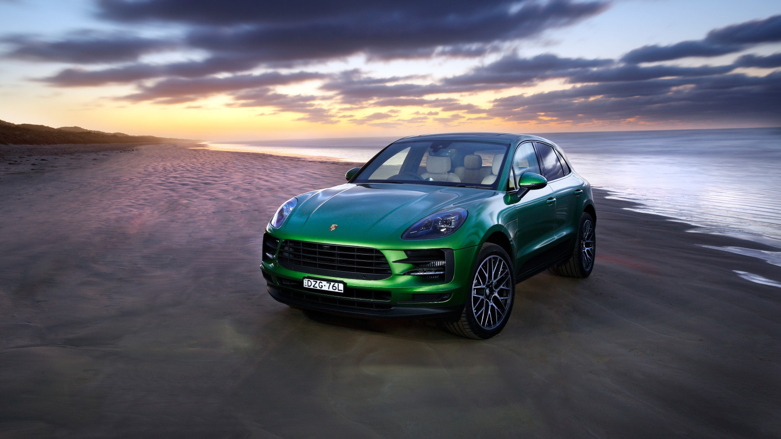 Зеленый автомобиль Porsche Macan S 2019 года на берегу океана 
