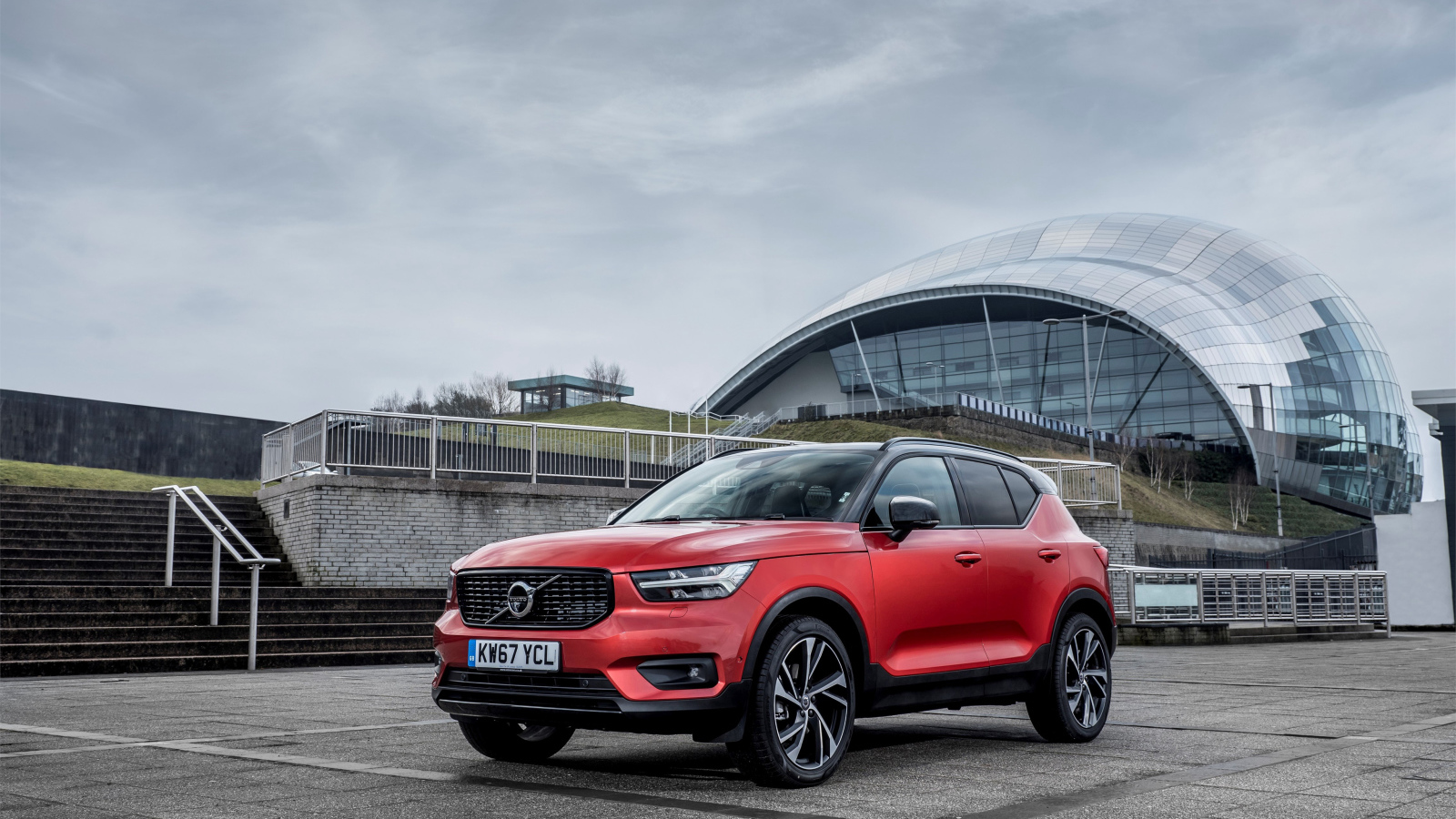 Красный внедорожник Volvo V60 на фоне пасмурного неба