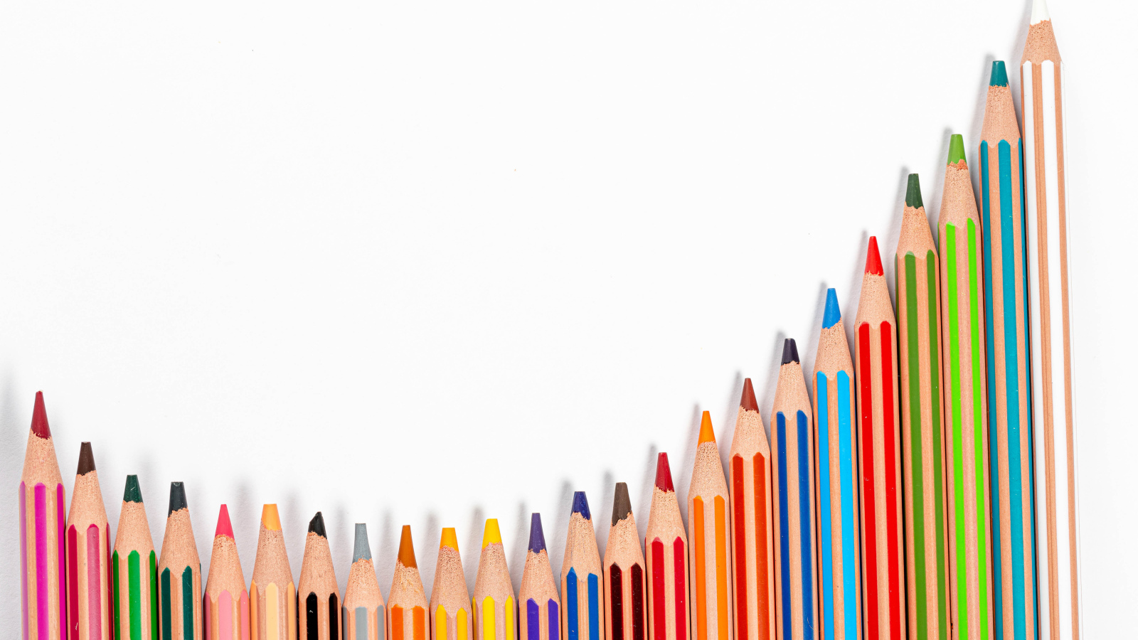 Много разноцветных карандашей на белом фоне