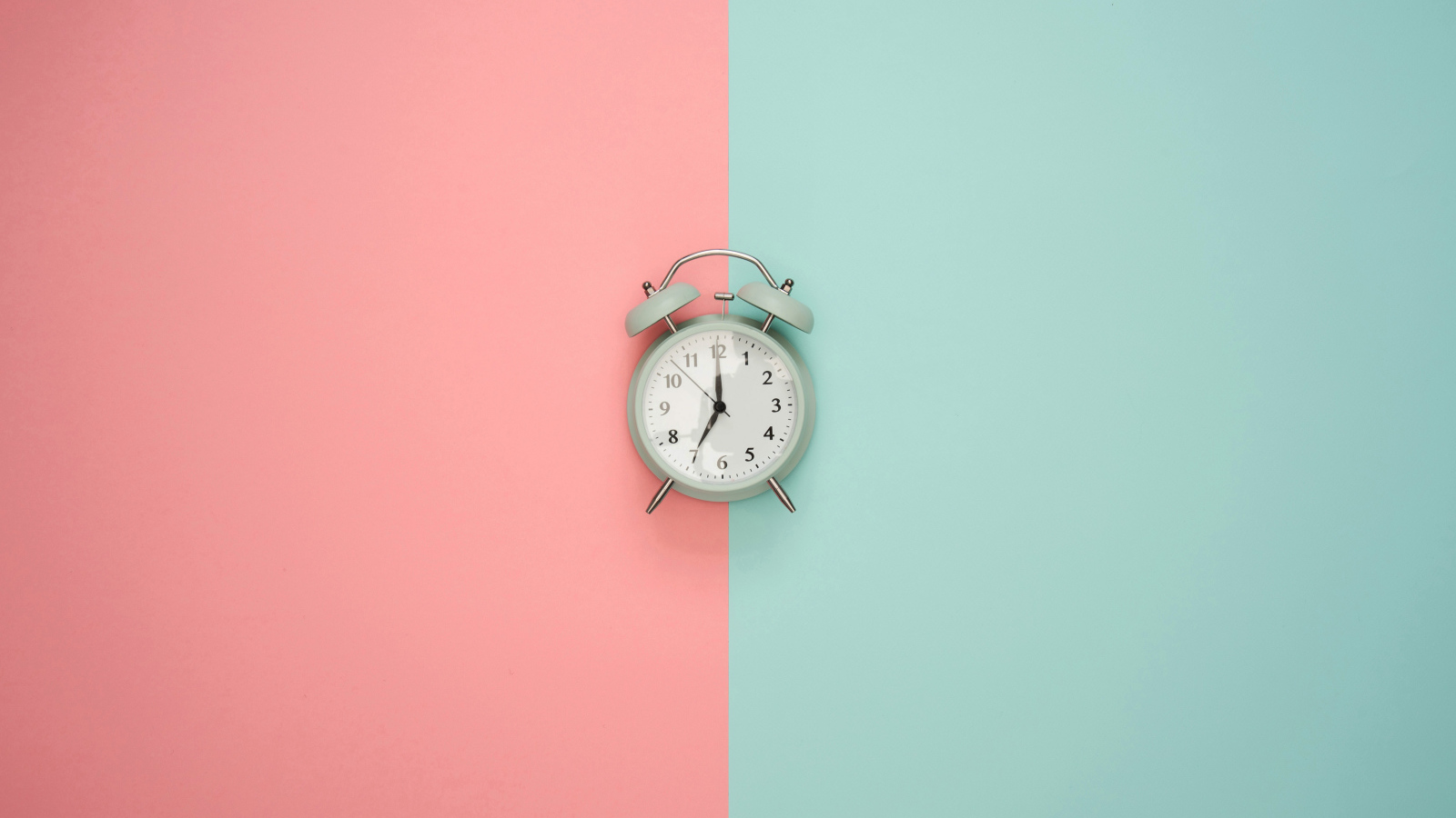 Серый будильник на разноцветном фоне