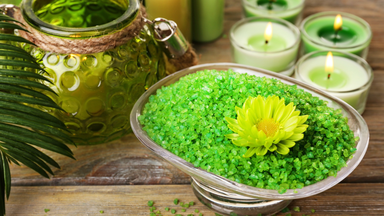 Зеленая ароматная морская соль на столе с зажженными свечами