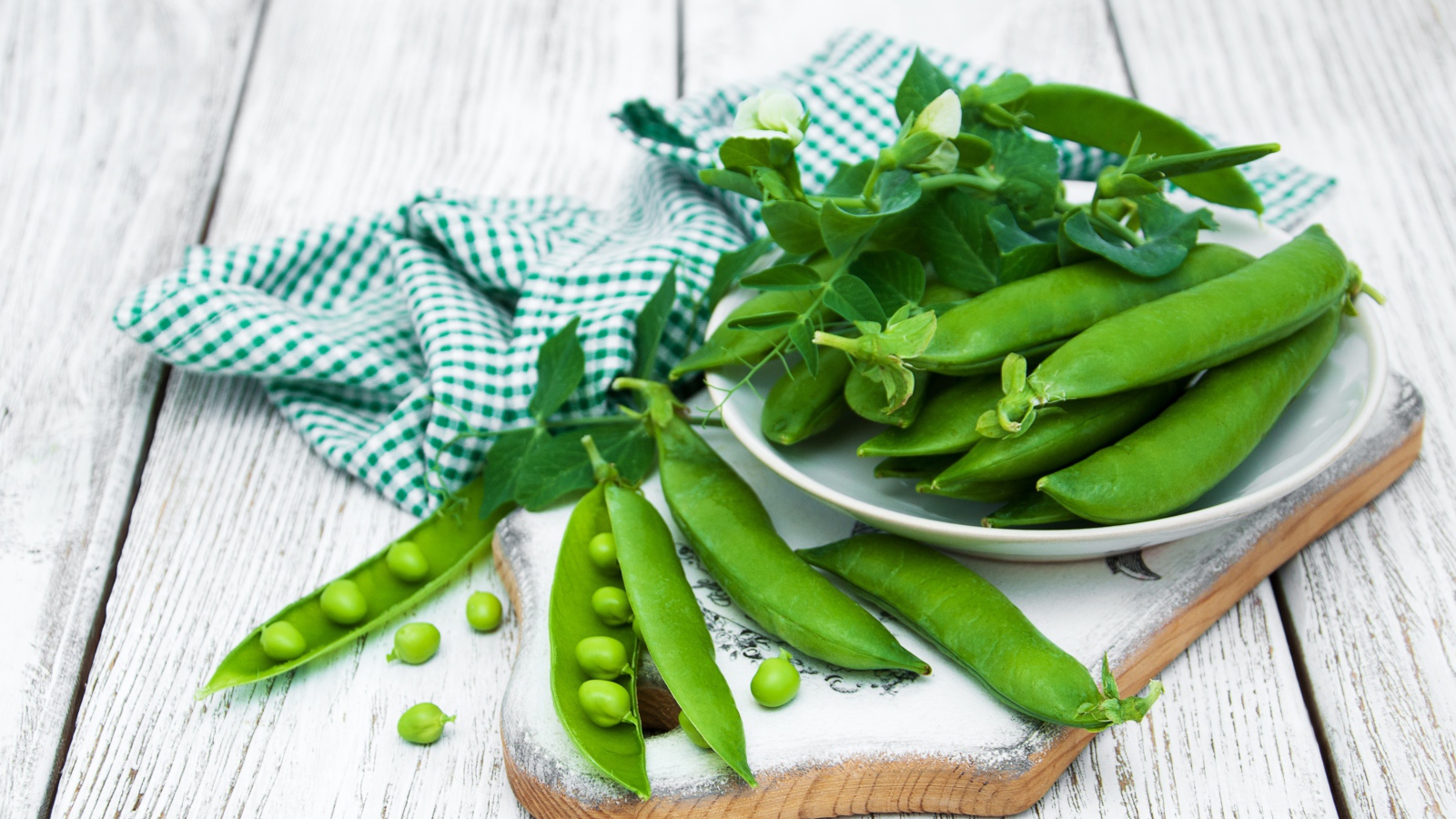 Свежий зеленый горох на столе с полотенцем