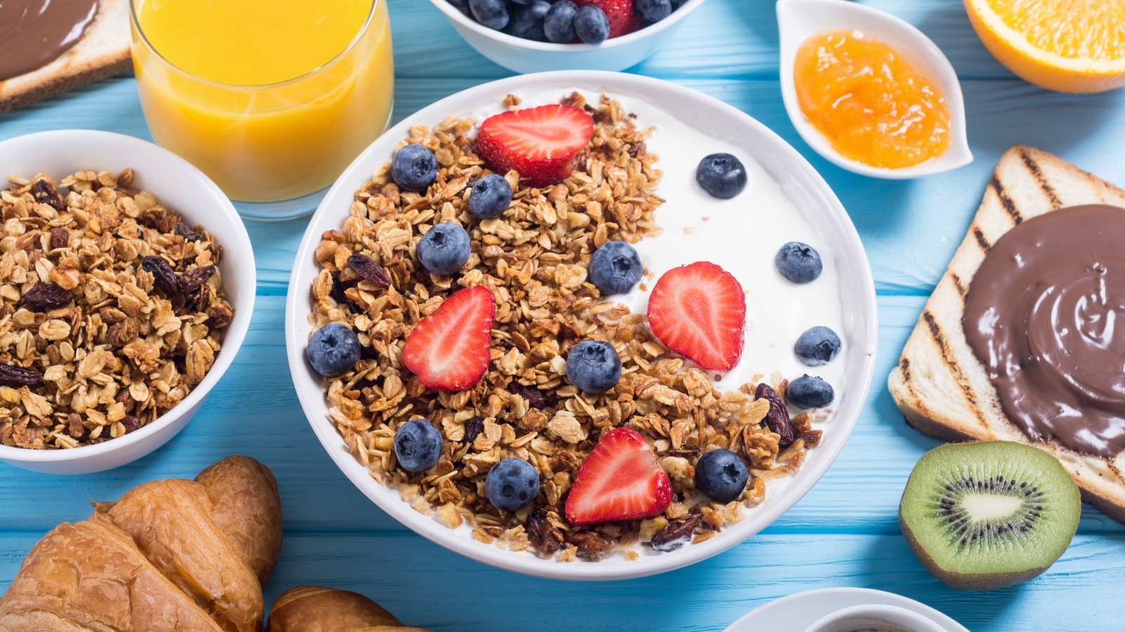 Мюсли с ягодами и молоком в тарелке на столе к завтраку