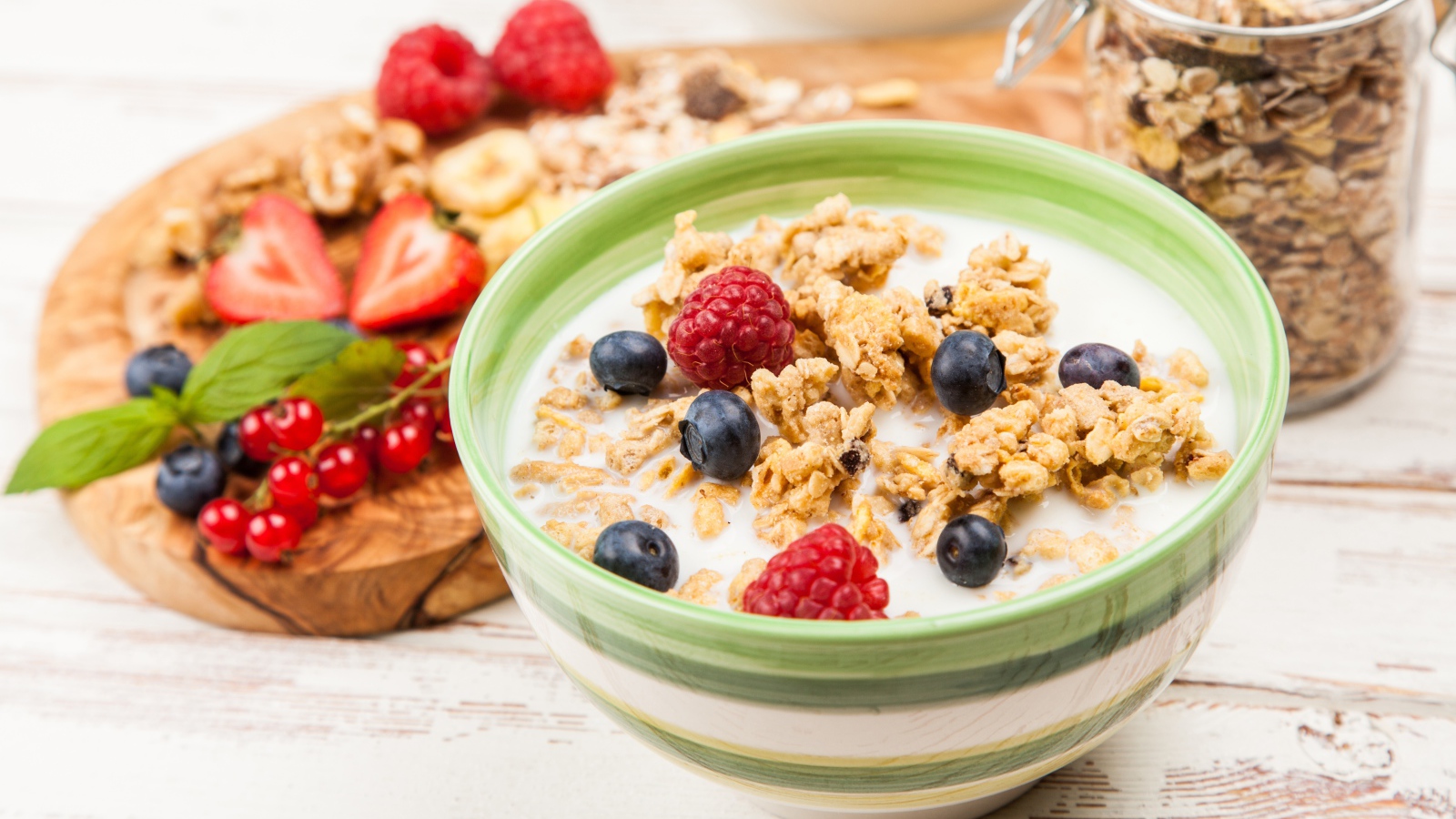 Мюсли с молоком и ягодами на столе к завтраку