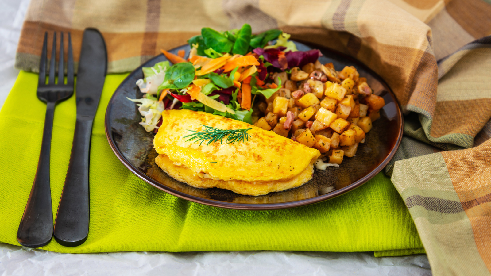 Омлет на тарелке с салатом и овощами