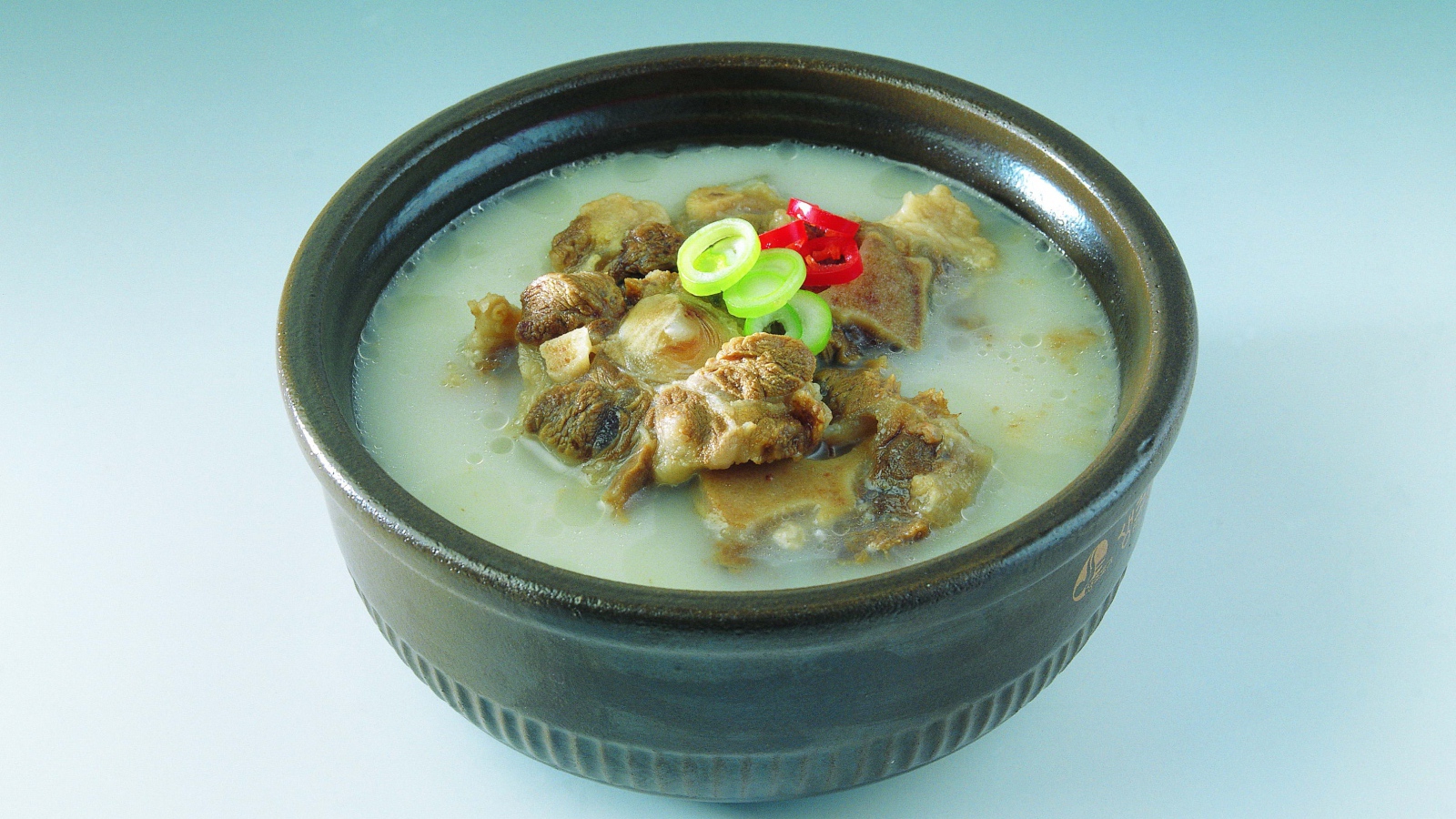 Тарелка супа с говядиной  на голубом фоне