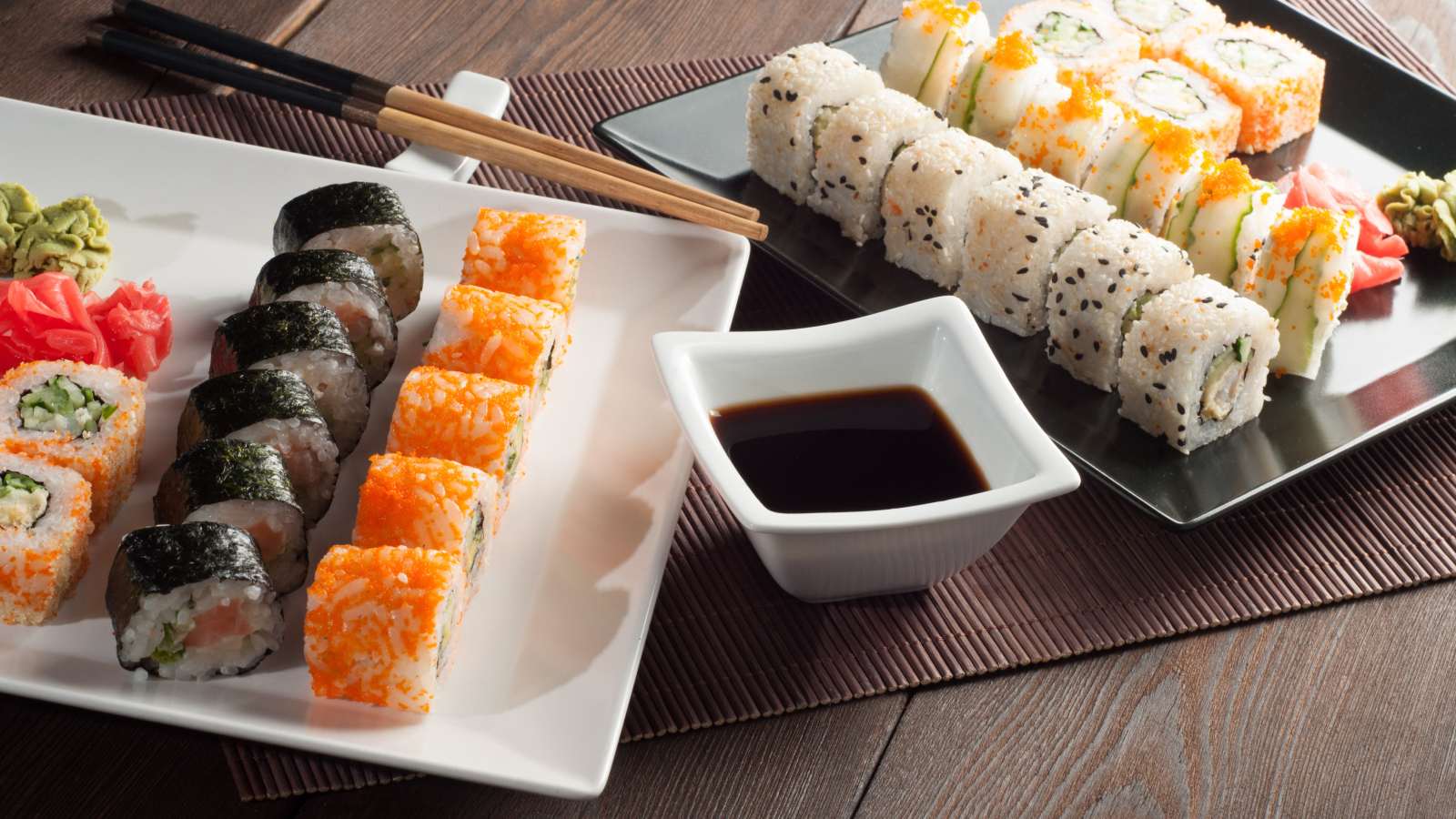 Суши на столе с соевым соусом и палочками