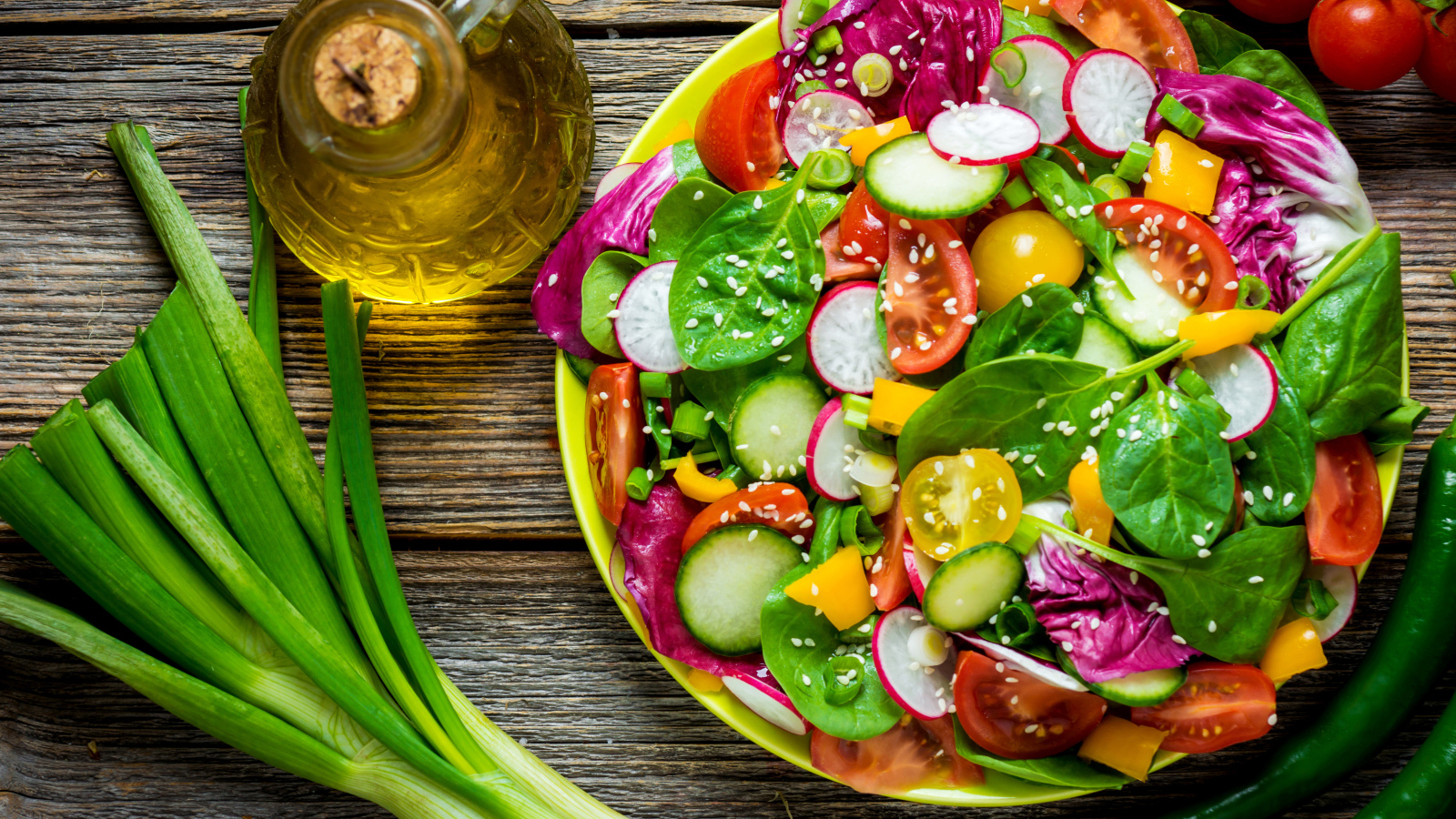 Овощной салат на столе с оливковым маслом и зеленым луком