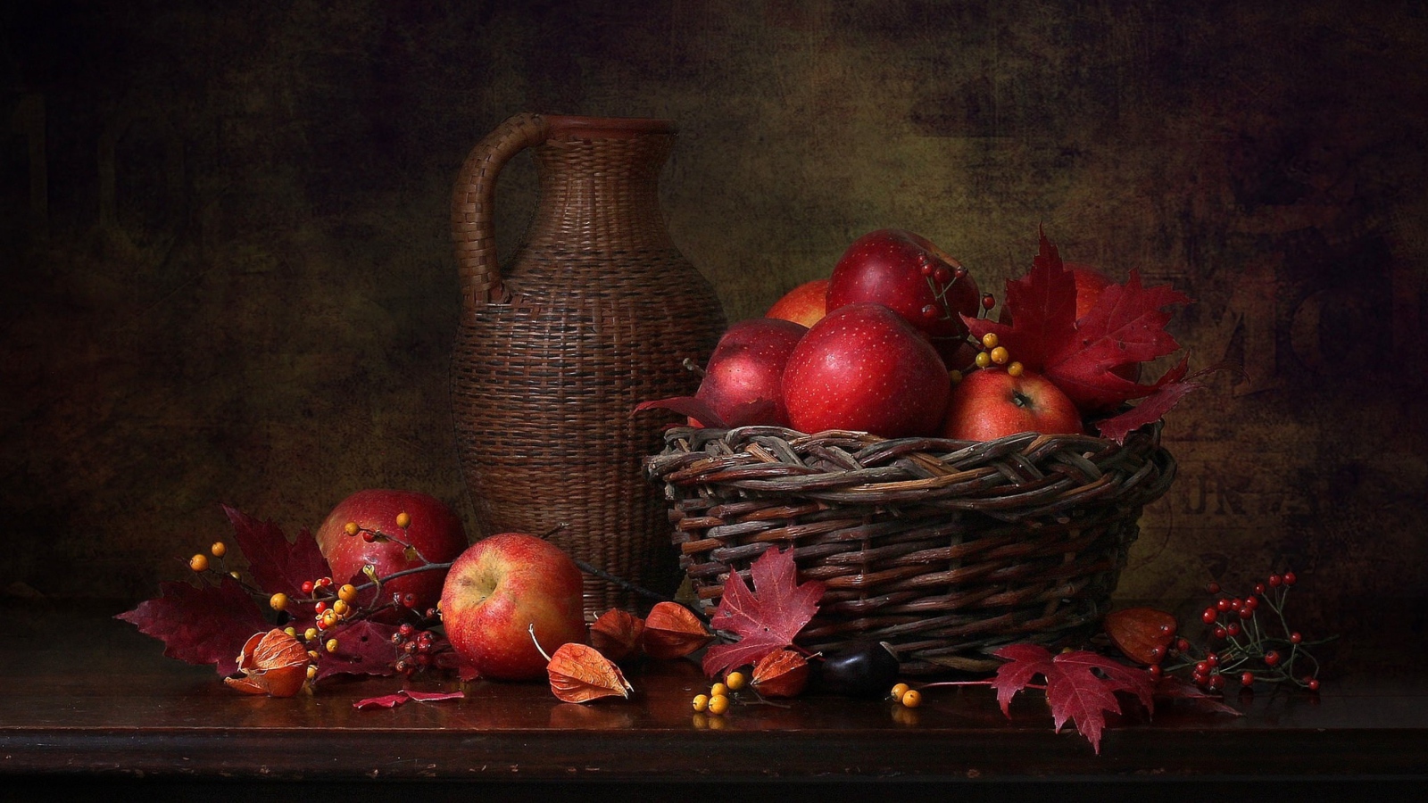 Корзина с красными яблоками на столе с кувшином 