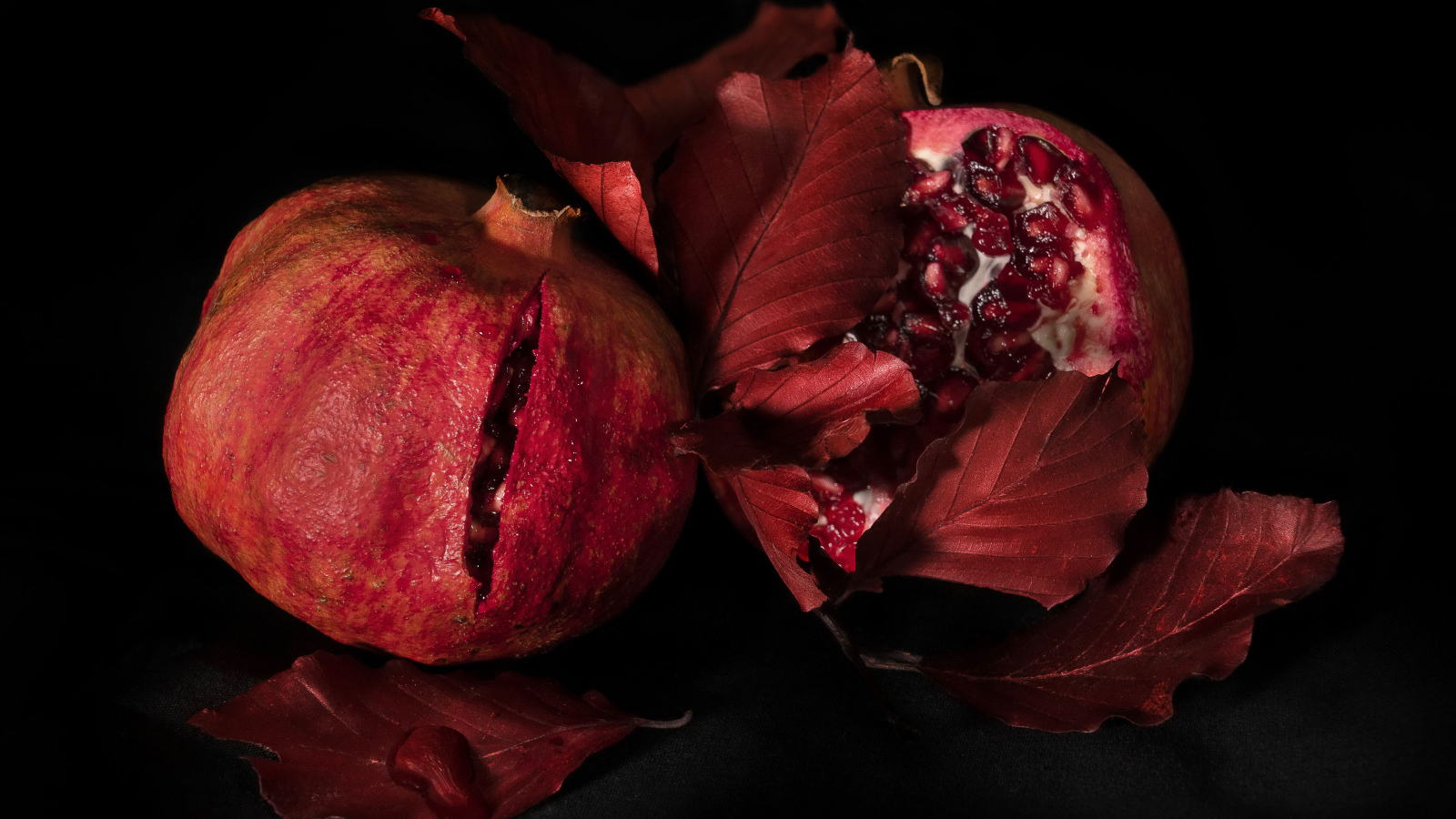 Два красных граната на черном фоне
