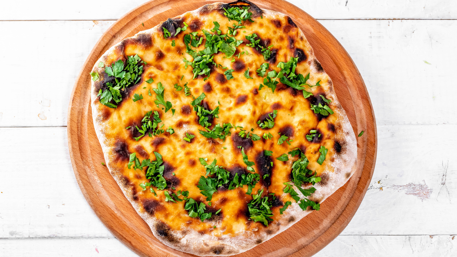 Пирог с сыром и зеленью на доске 