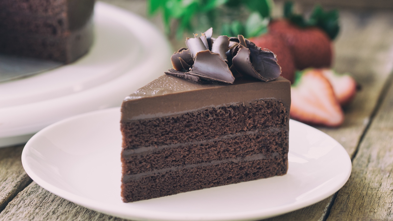 Кусок торта с шоколадом на белой тарелке