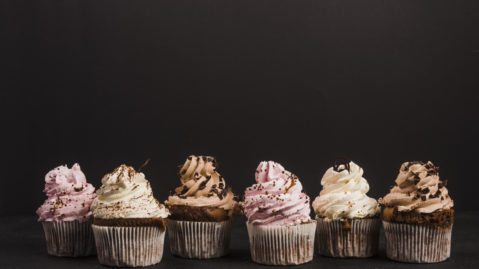 Аппетитные кексы с кремом на сером фоне