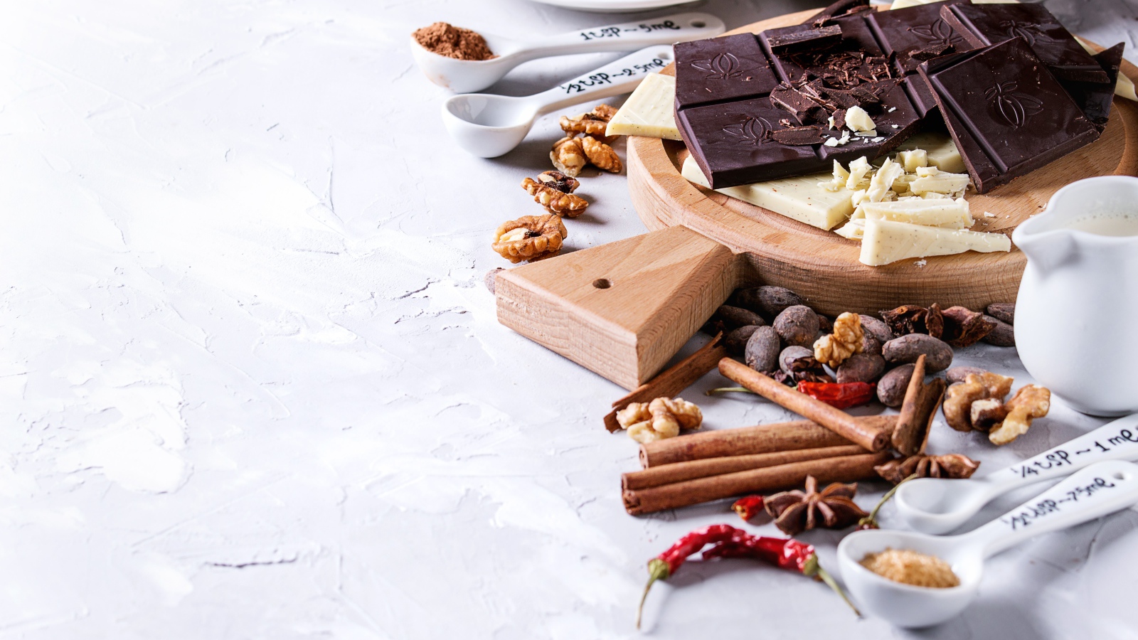 Черный и молочный шоколад на столе с орехами