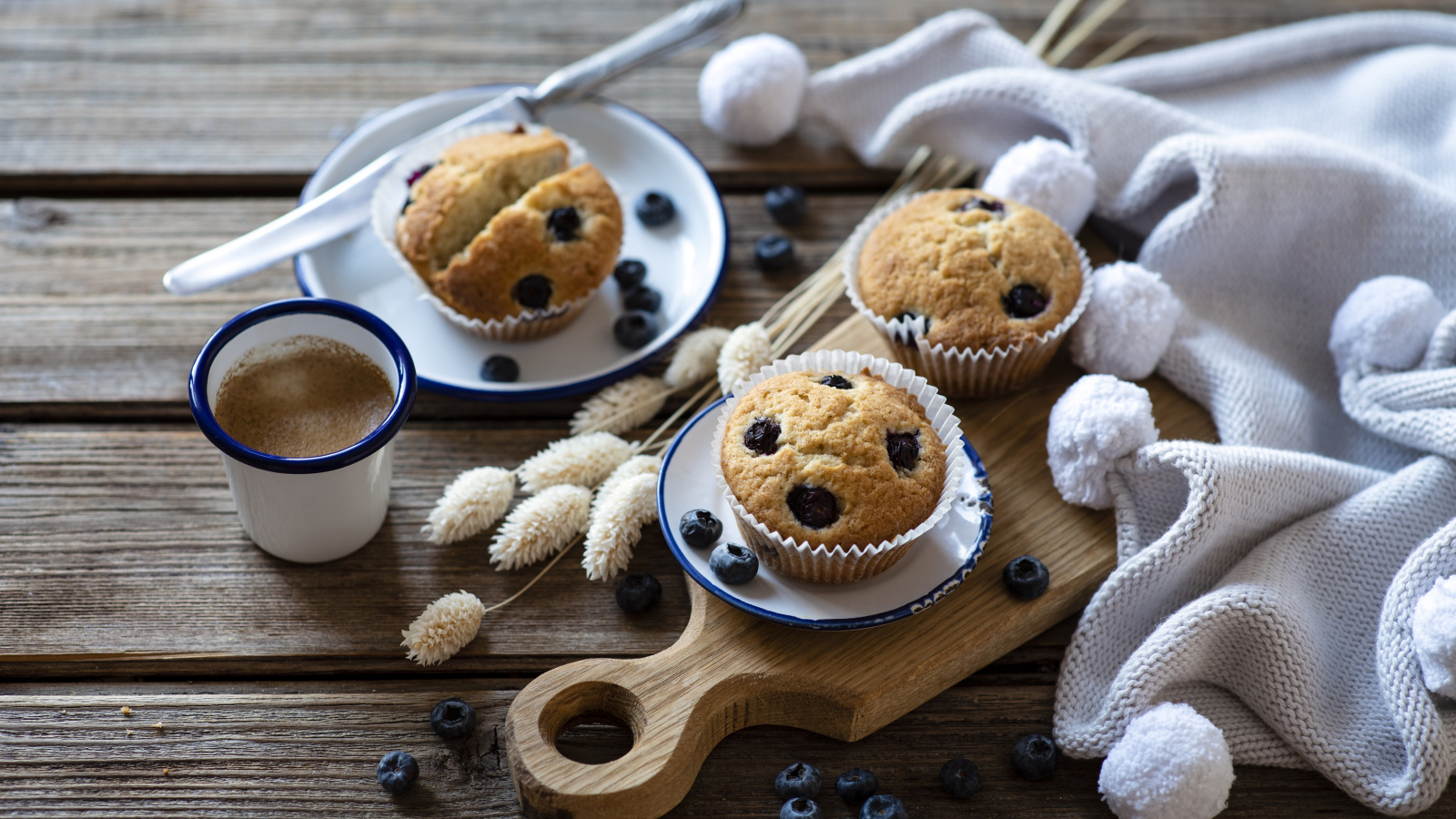 Кексы с черникой на столе с колосьями и кофе