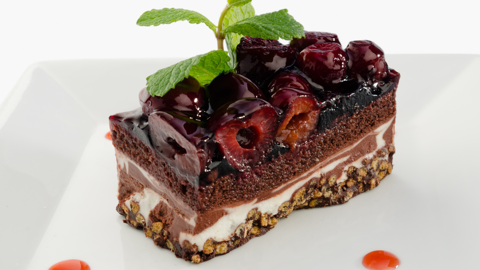 Пирожное с черешней и листиками мяты на сером фоне