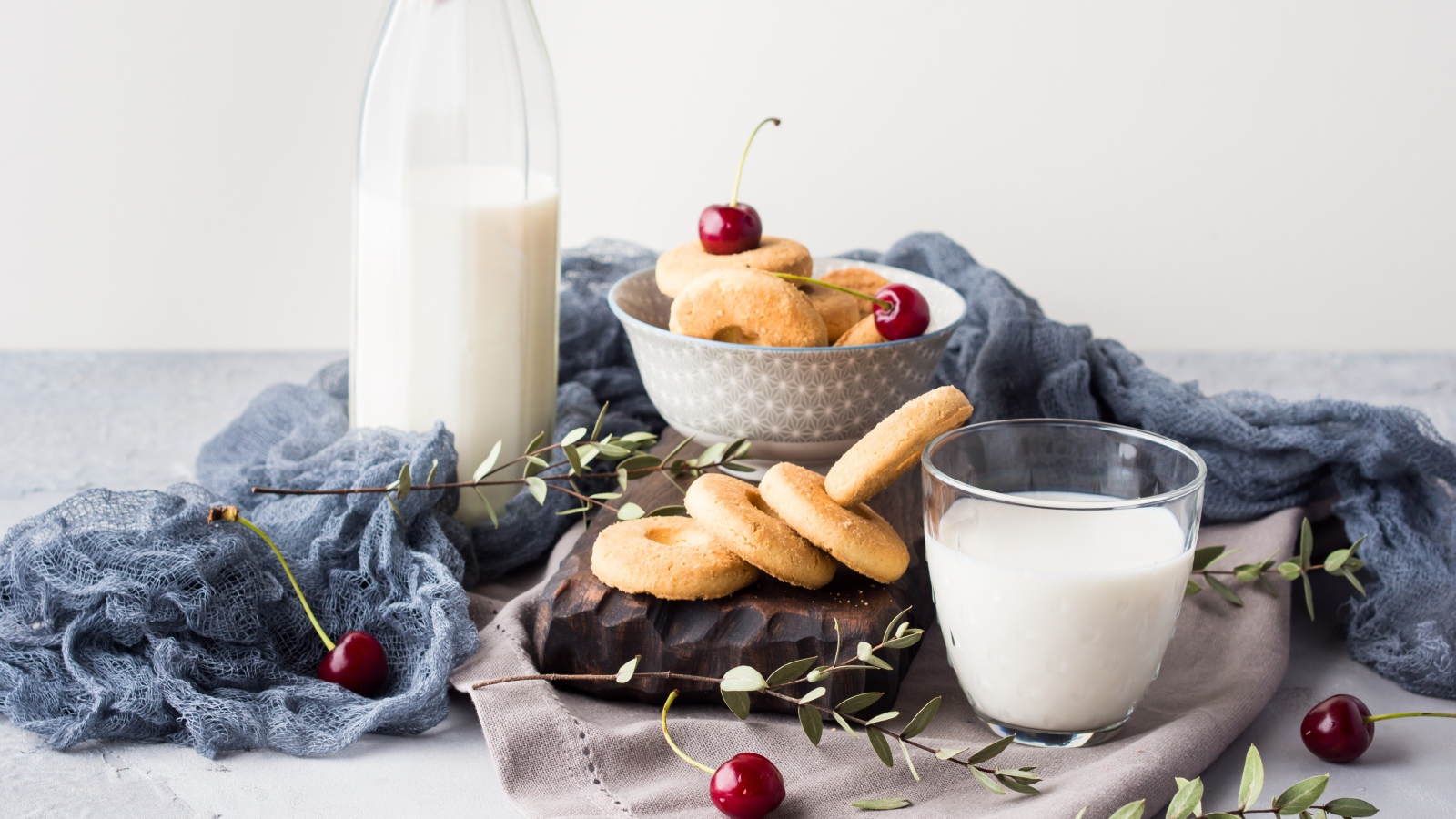 Печенье на столе с молоком и черешней