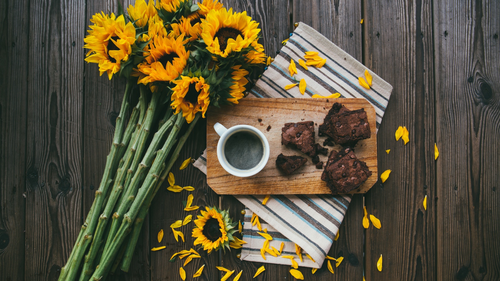 Чашка кофе на столе с пирогом и букетом подсолнухов