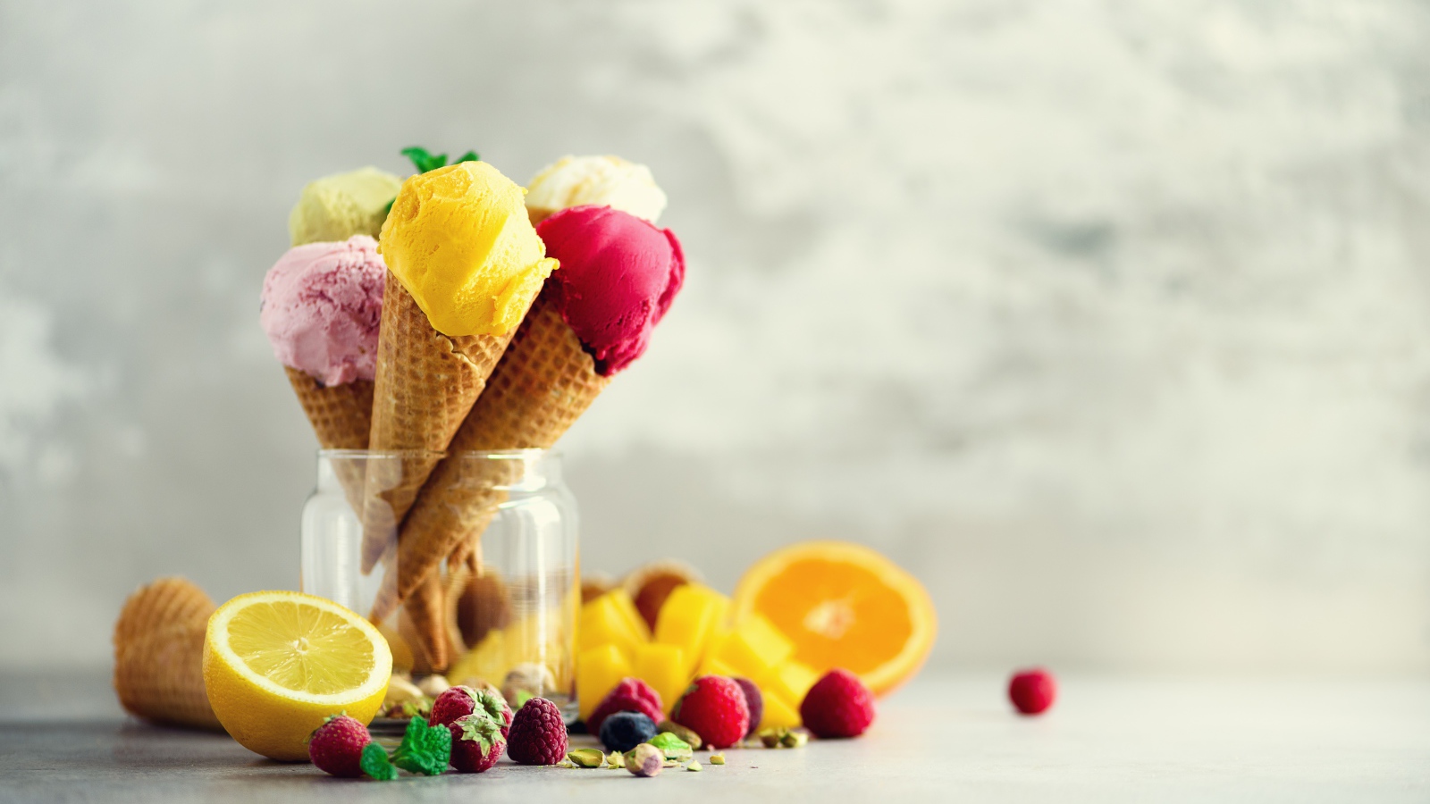 Фруктовое мороженое в вафельных рожках на столе с ягодами и фруктами