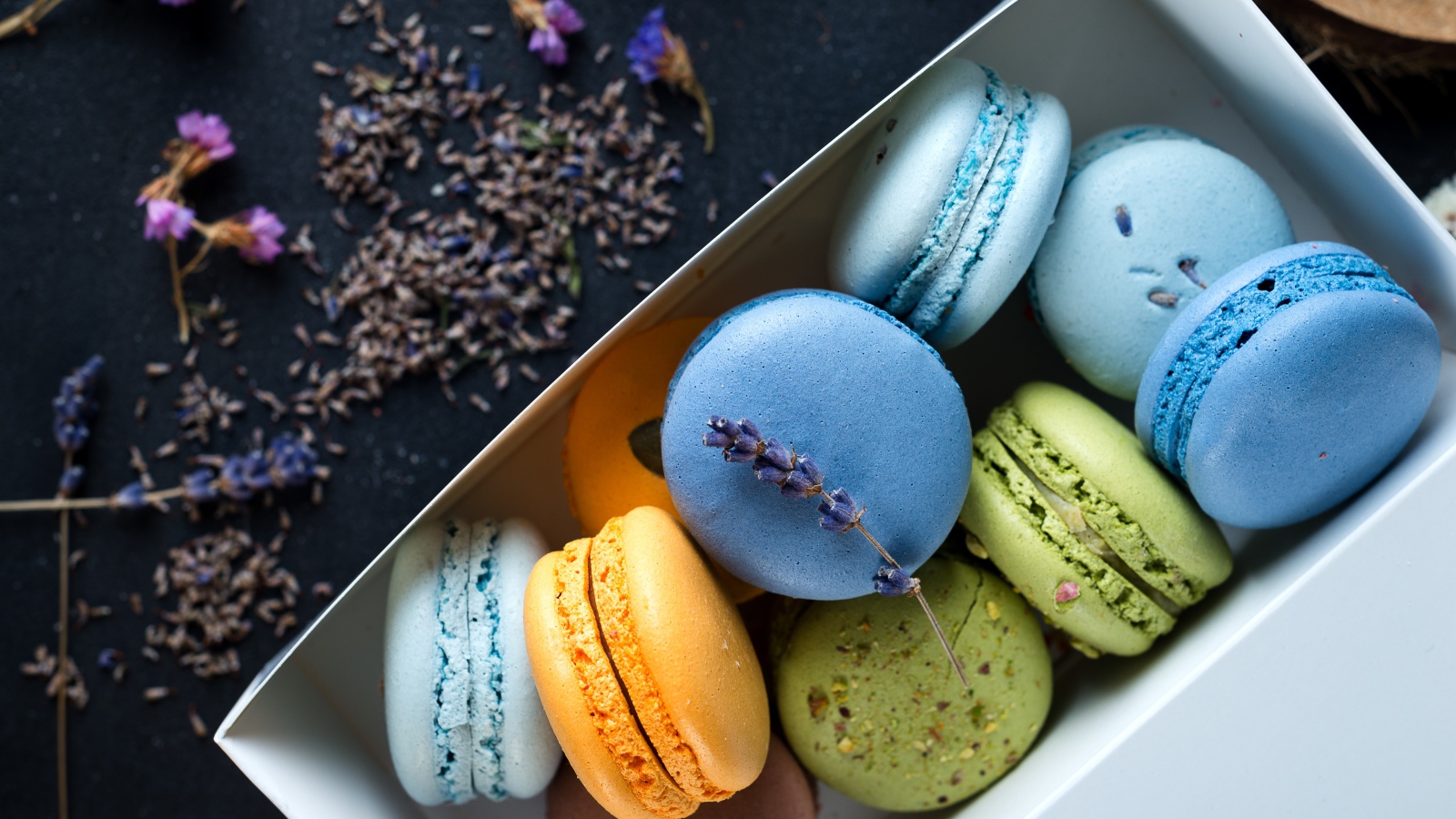 Разноцветный десерт макарон в коробке на столе с лавандой