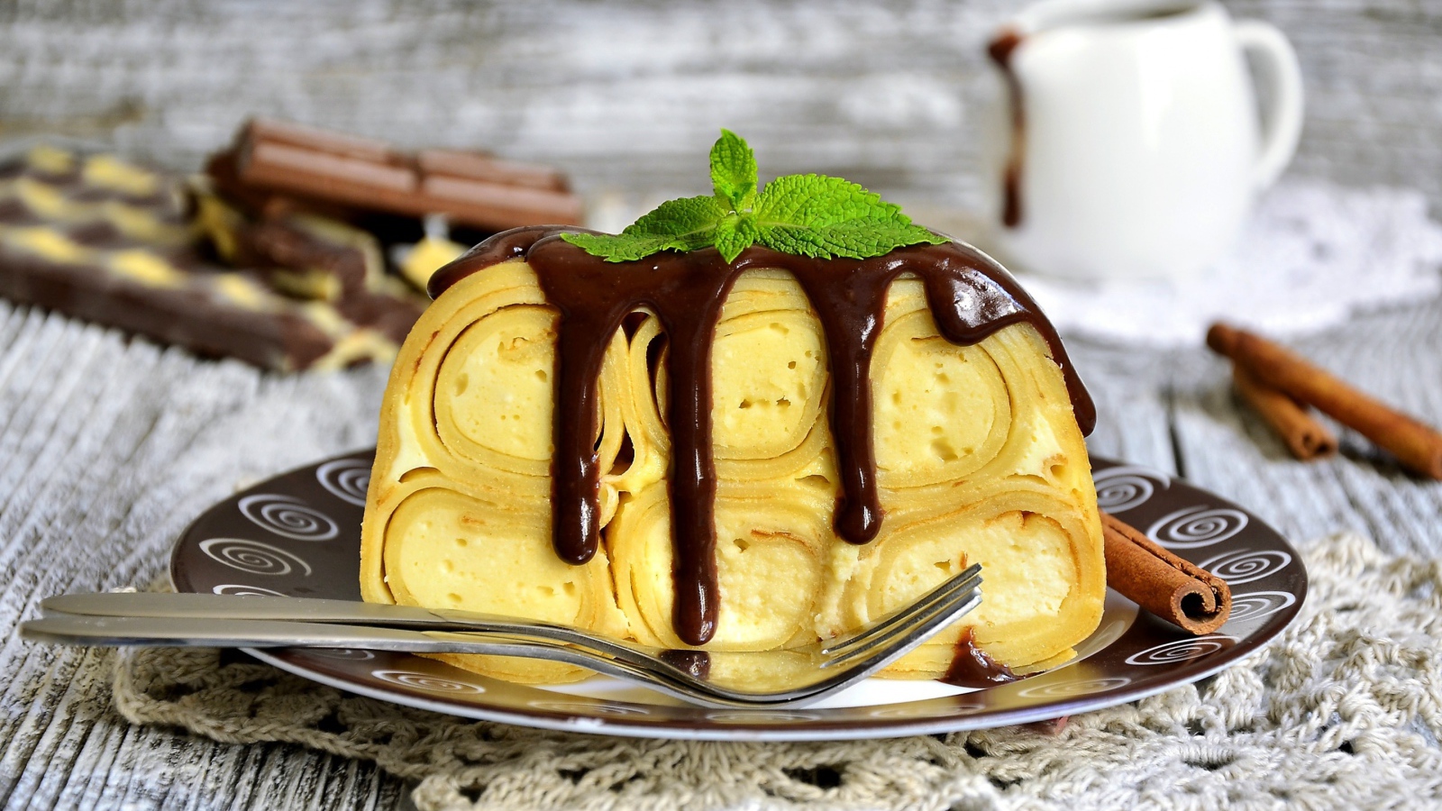 Блинный торт с творогом и шоколадом на тарелке 