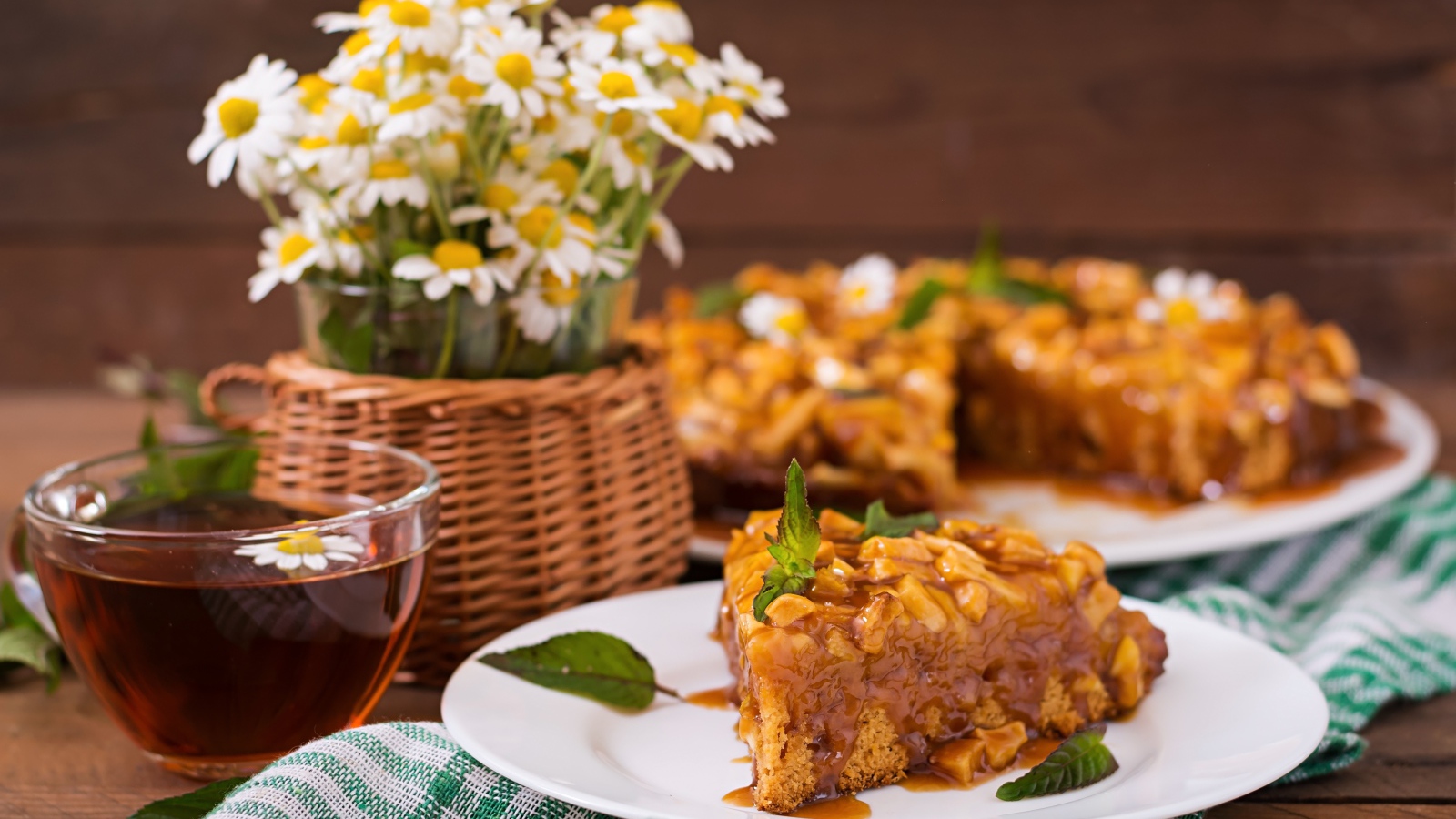 Пирог на столе с чаем и букетом ромашек