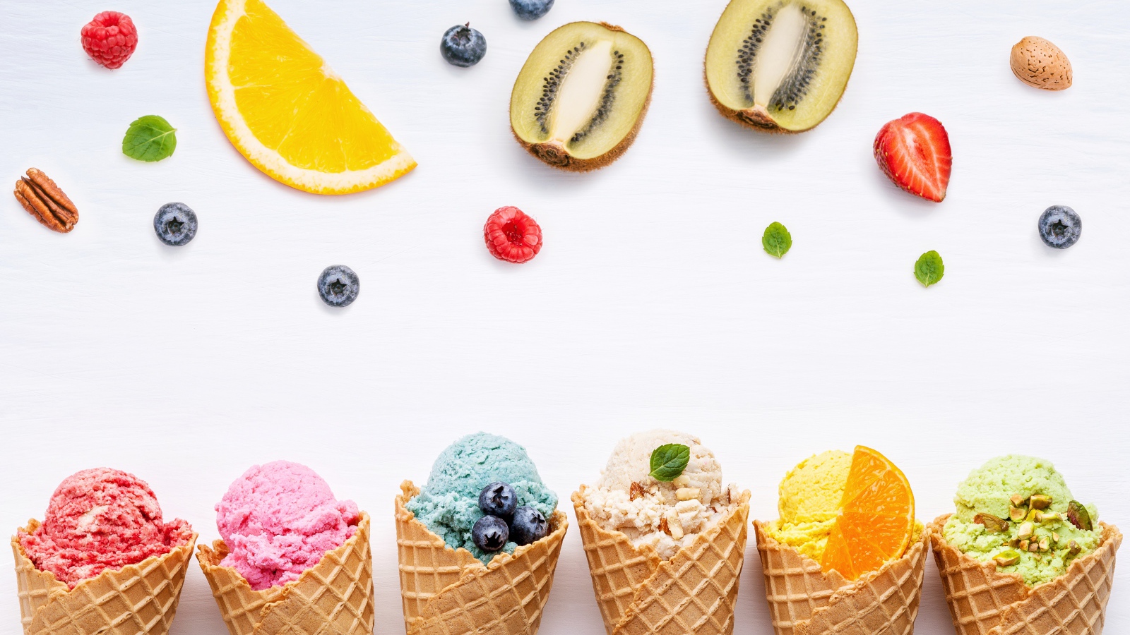 Фруктовое мороженое в вафельных рожках на белом фоне с ягодами