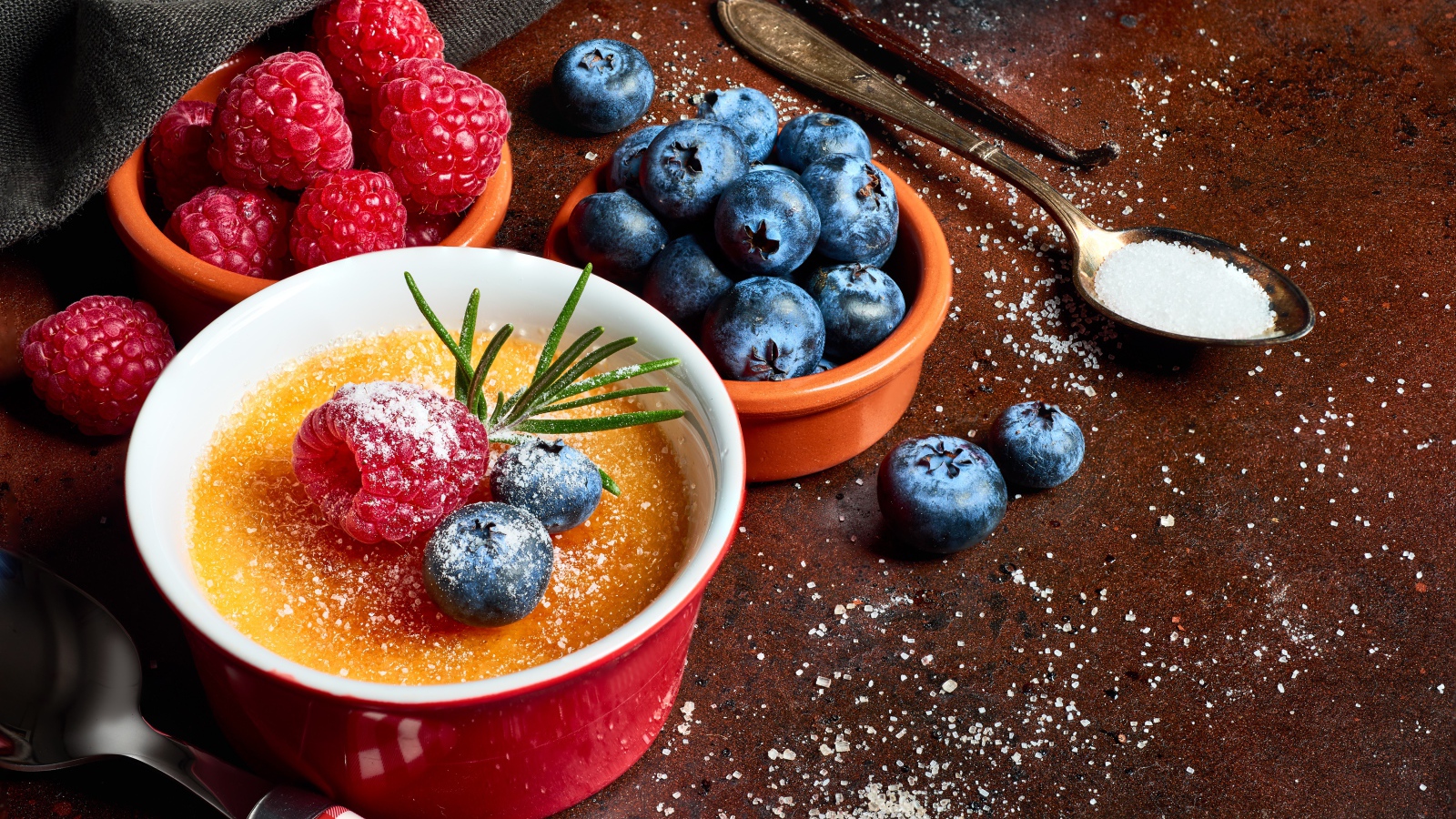 Пудинг на столе с ягодами малины и черники