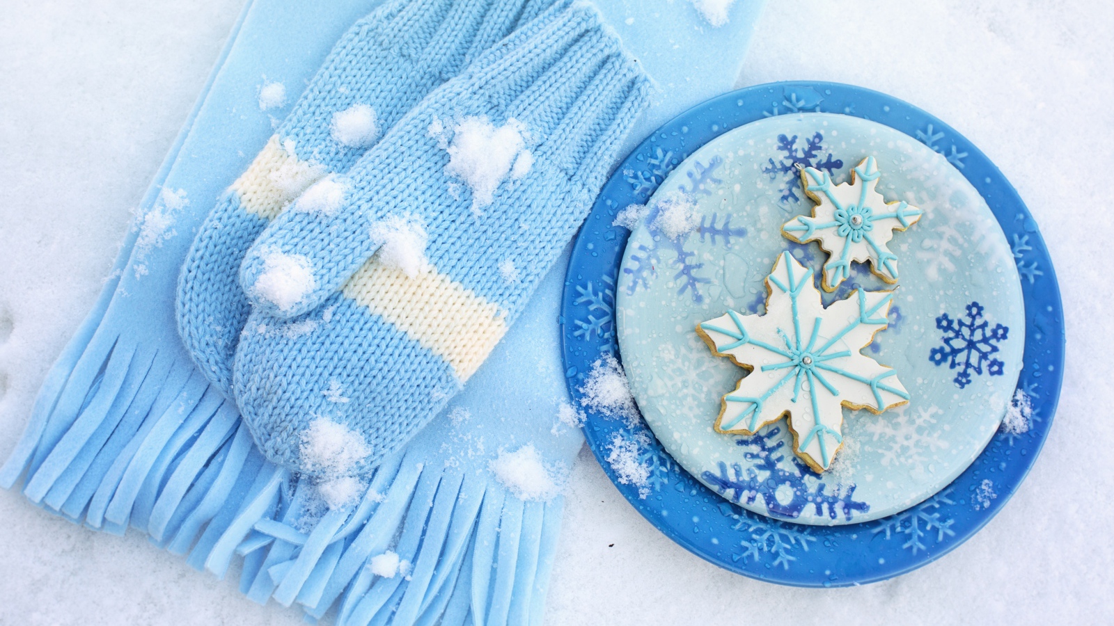 Печенье снежинки на снегу с шарфом и рукавицами