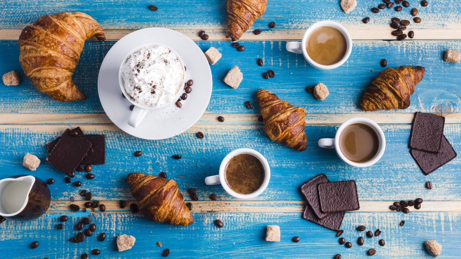 Сладости с кофе на голубом столе