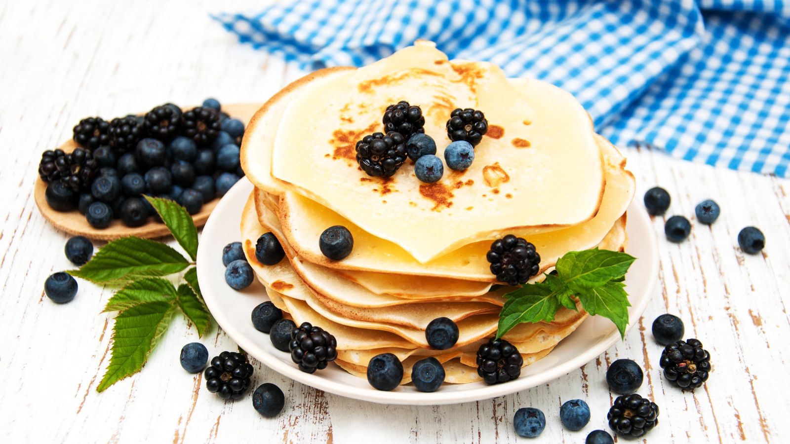 Румяные тонкие блинчики с ягодами черники и ежевики