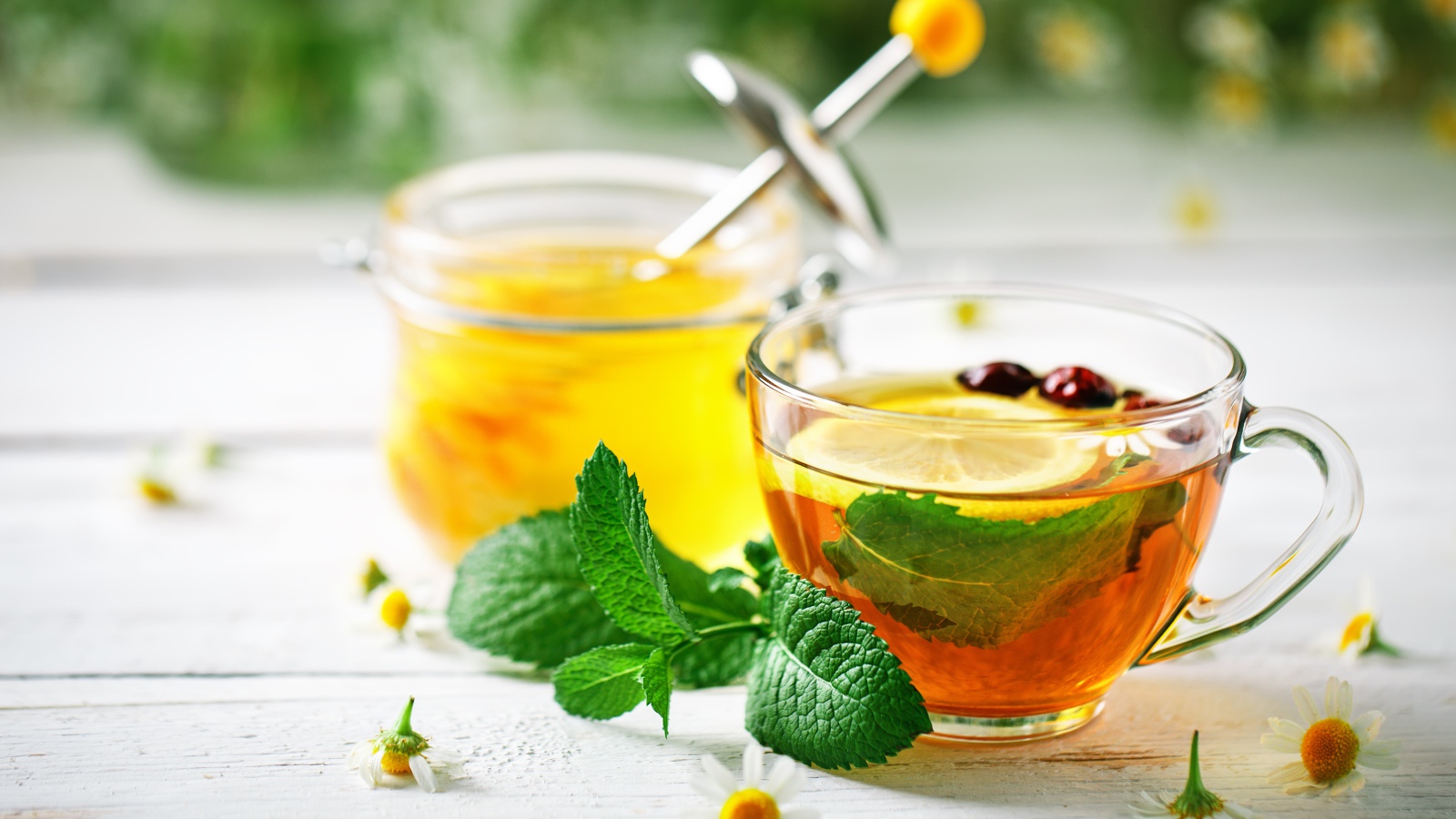 Чашка чая с лимоном и мятой на столе с медом