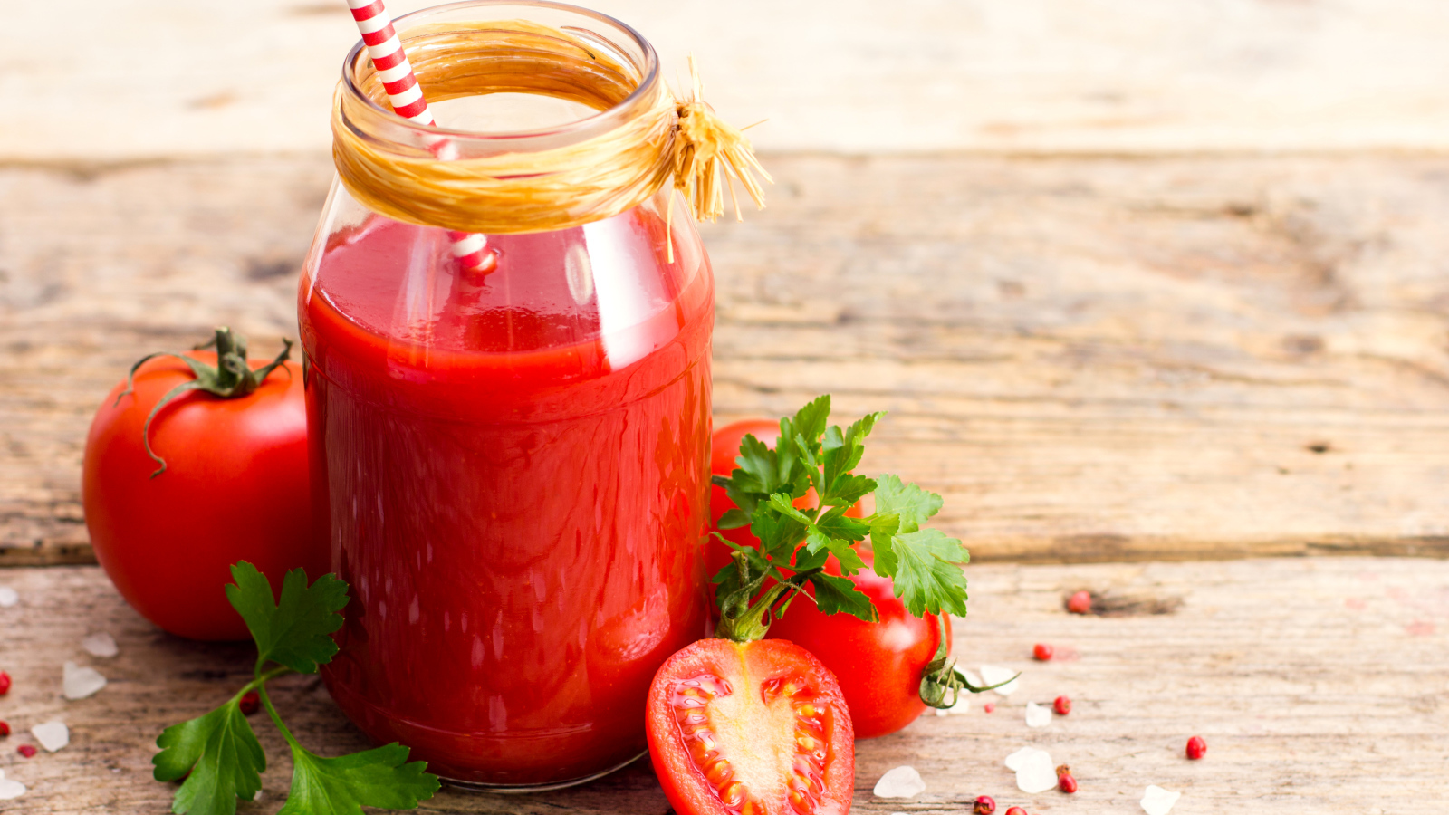 Банка томатного сока на столе с помидорами и петрушкой