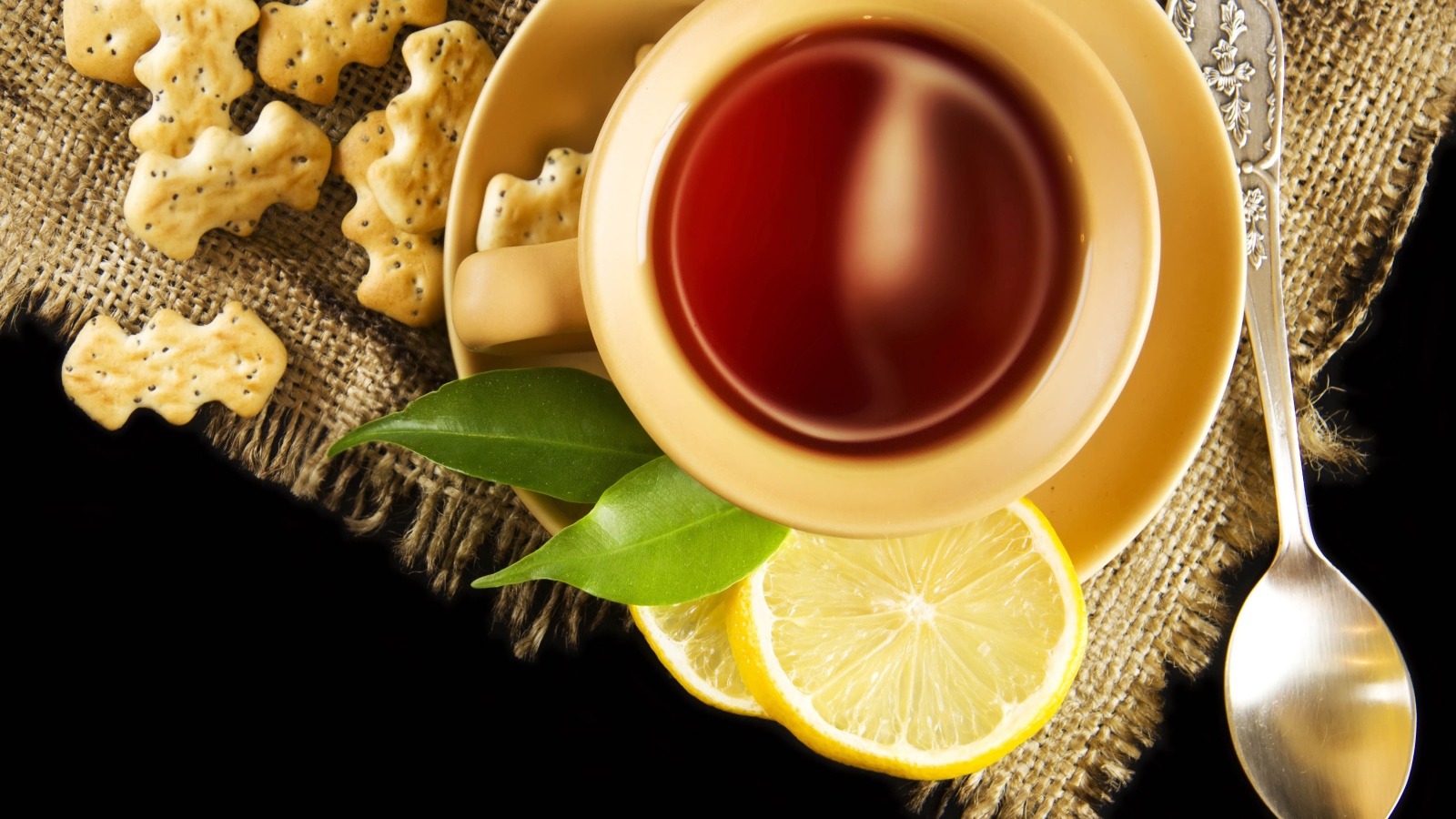 Чай на столе с печеньем и кусочками лимона