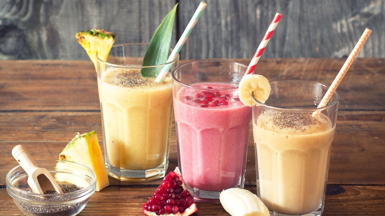 Три стакана смузи на столе с трубочками